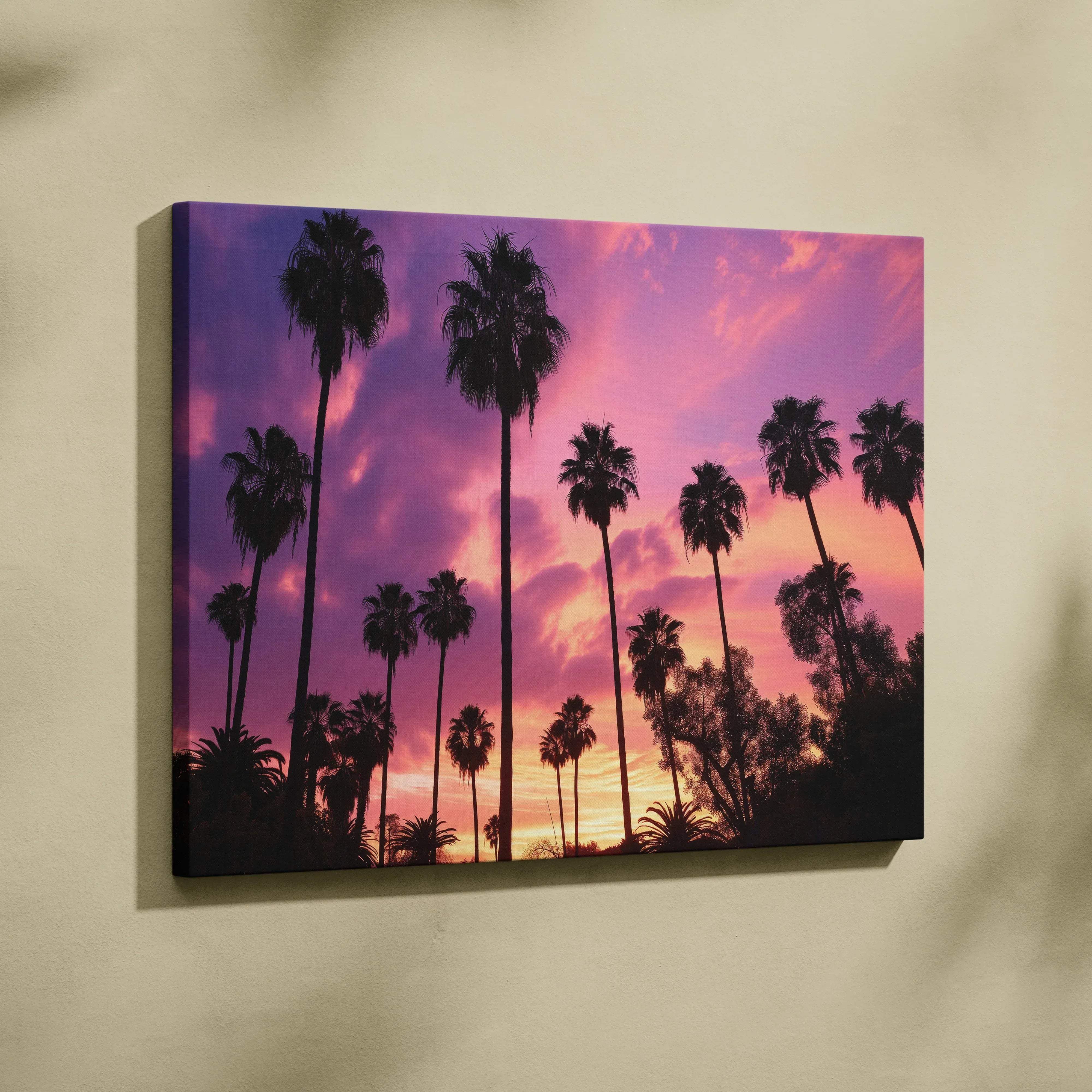 A vibrant canvas wall art featuring silhouetted palm trees against a pink and purple gradient sunset sky