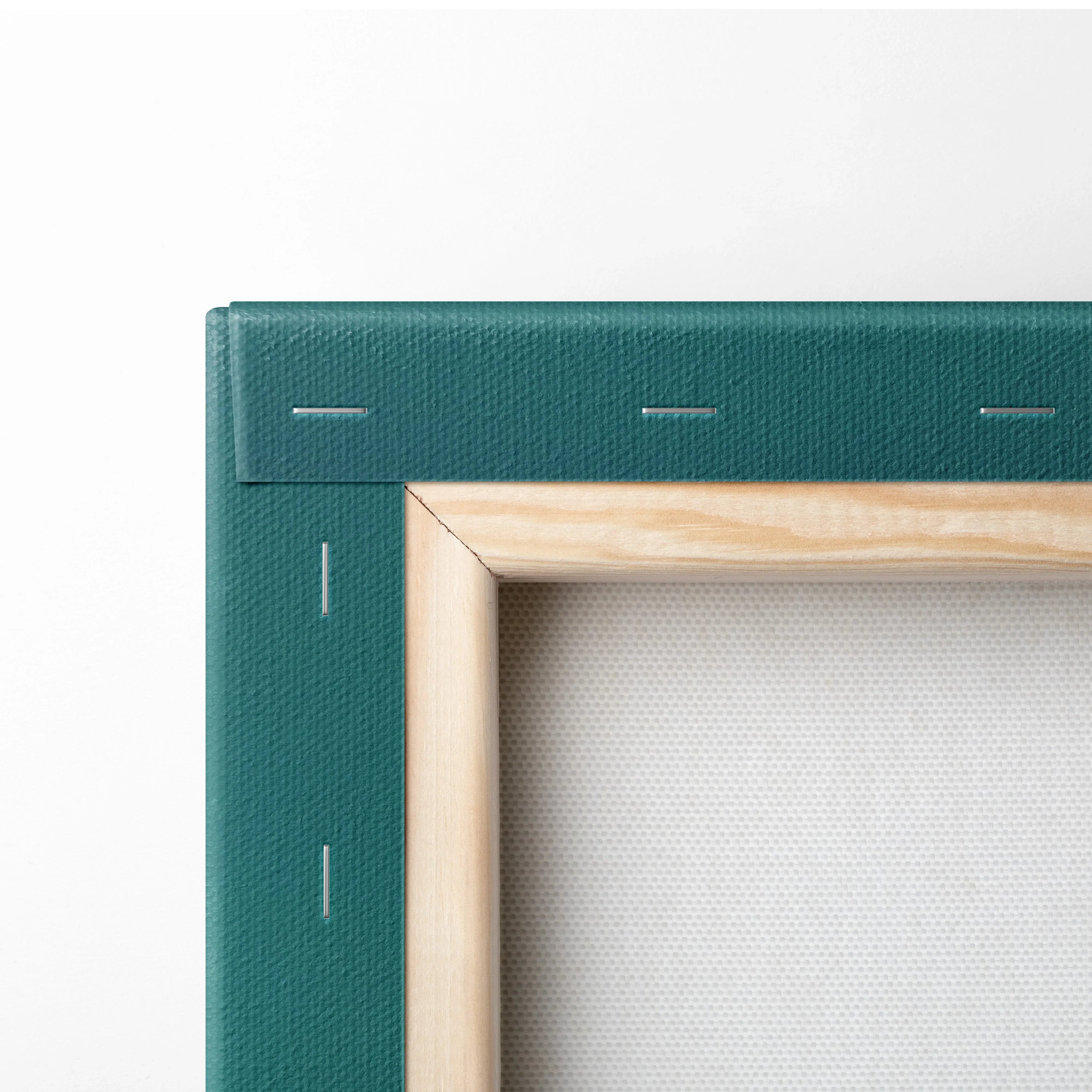 Close-up of wooden frame and green stapled edge of blank canvas wall art panel.
