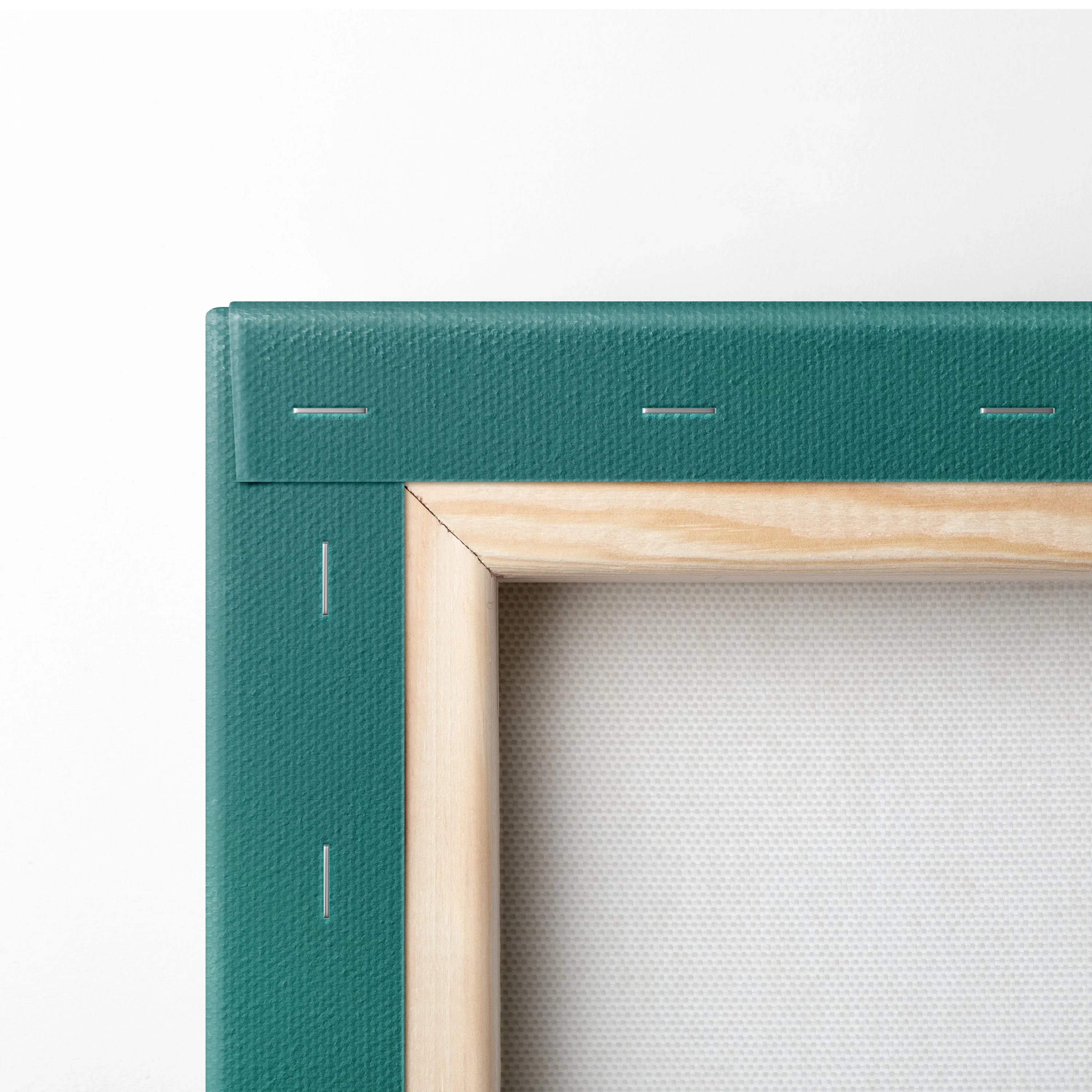 Close-up of wooden frame and teal edge stretched canvas wall art with visible staples and textured fabric surface.