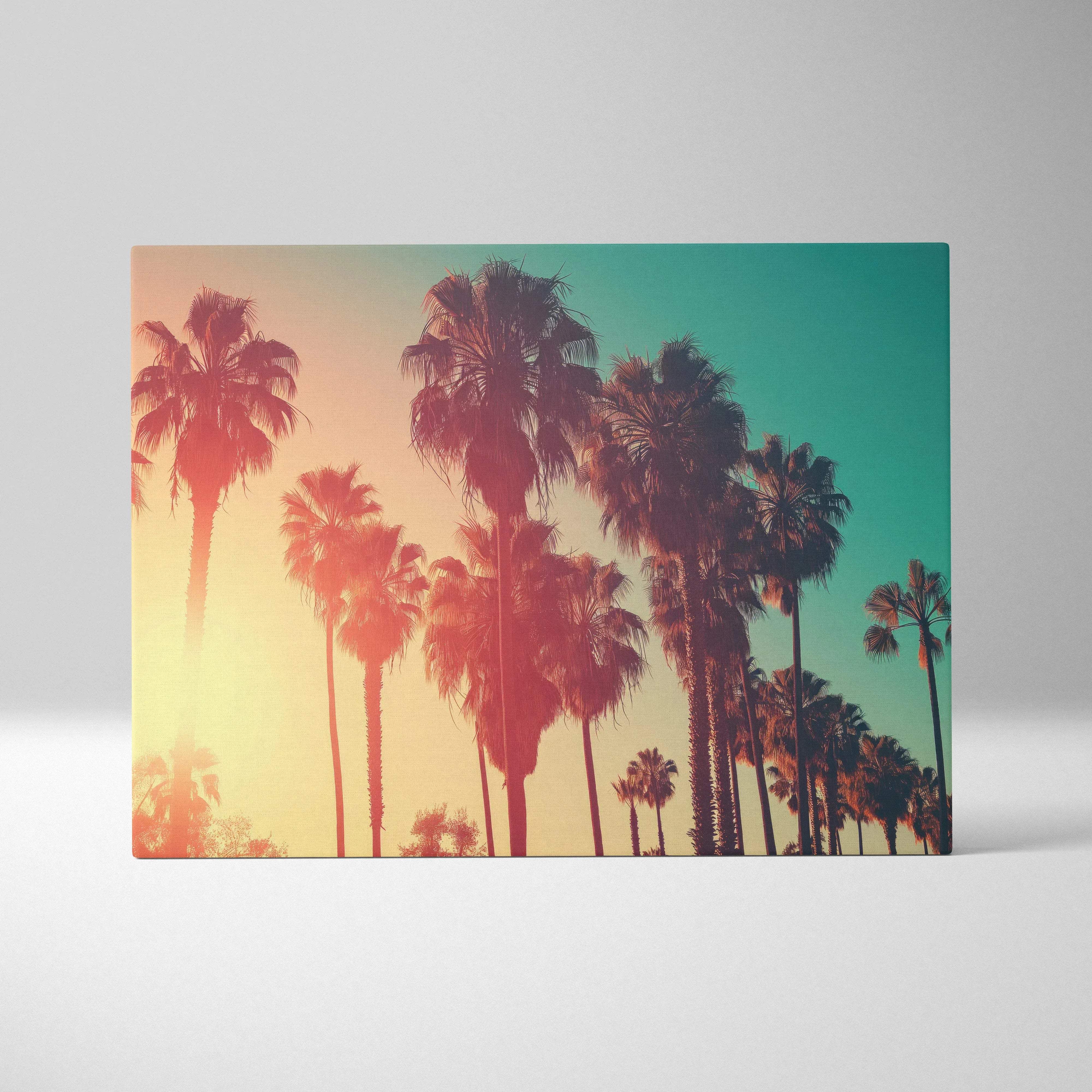 A rectangular canvas print featuring silhouetted palm trees against a warm amber to teal gradient sky for living room wall art
