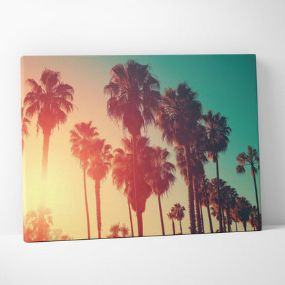 Canvas wall art featuring silhouettes of tall palm trees against a warm amber and teal sunset sky.