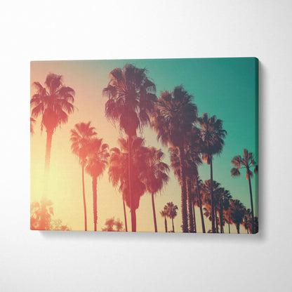Canvas wall art featuring palm tree silhouettes against a warm amber and teal sunset sky.