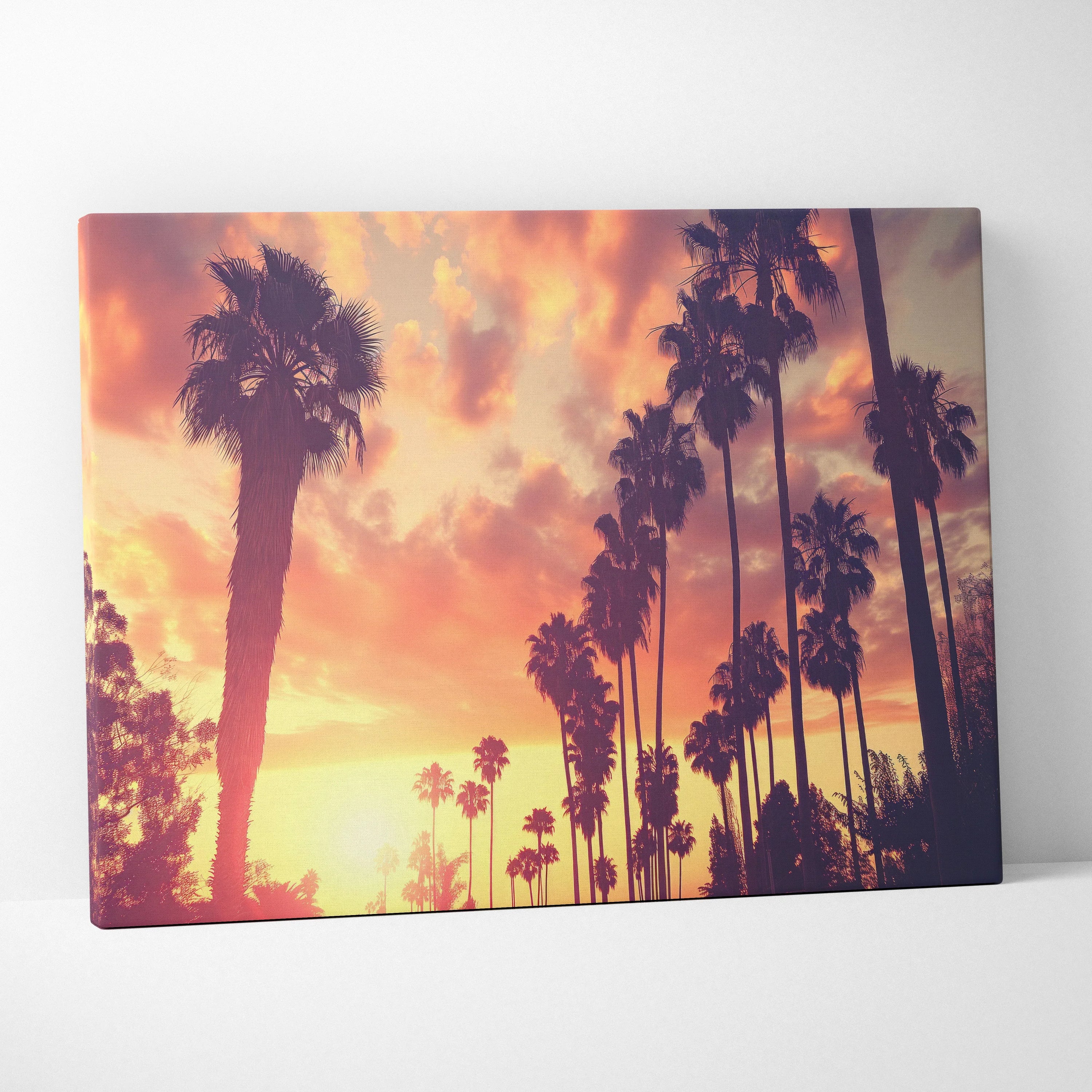 Canvas art featuring a tropical palm tree silhouette against a vibrant orange and purple sunset sky for modern wall decor.