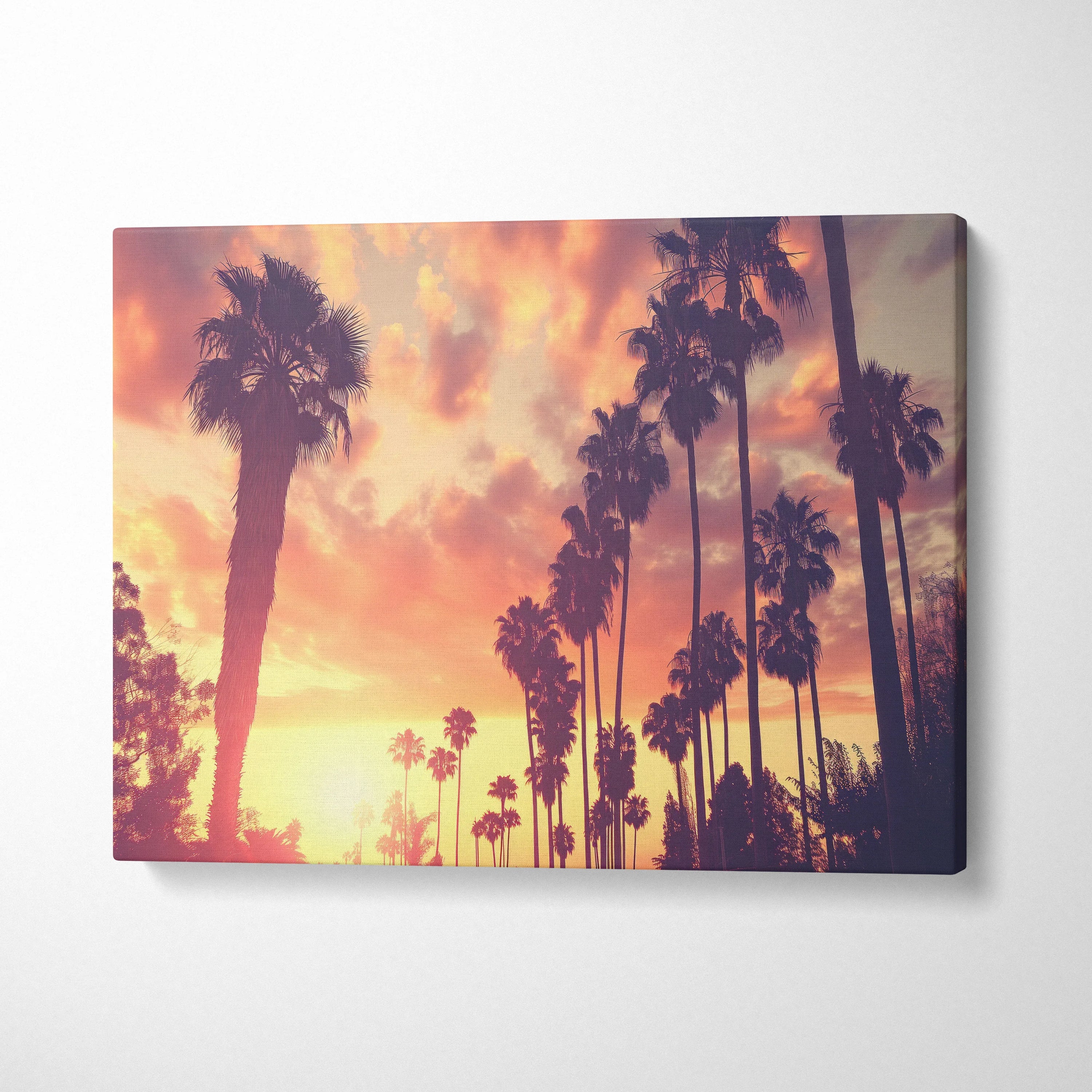Tropical palm trees silhouetted against vibrant sunset sky on canvas wall art decor.