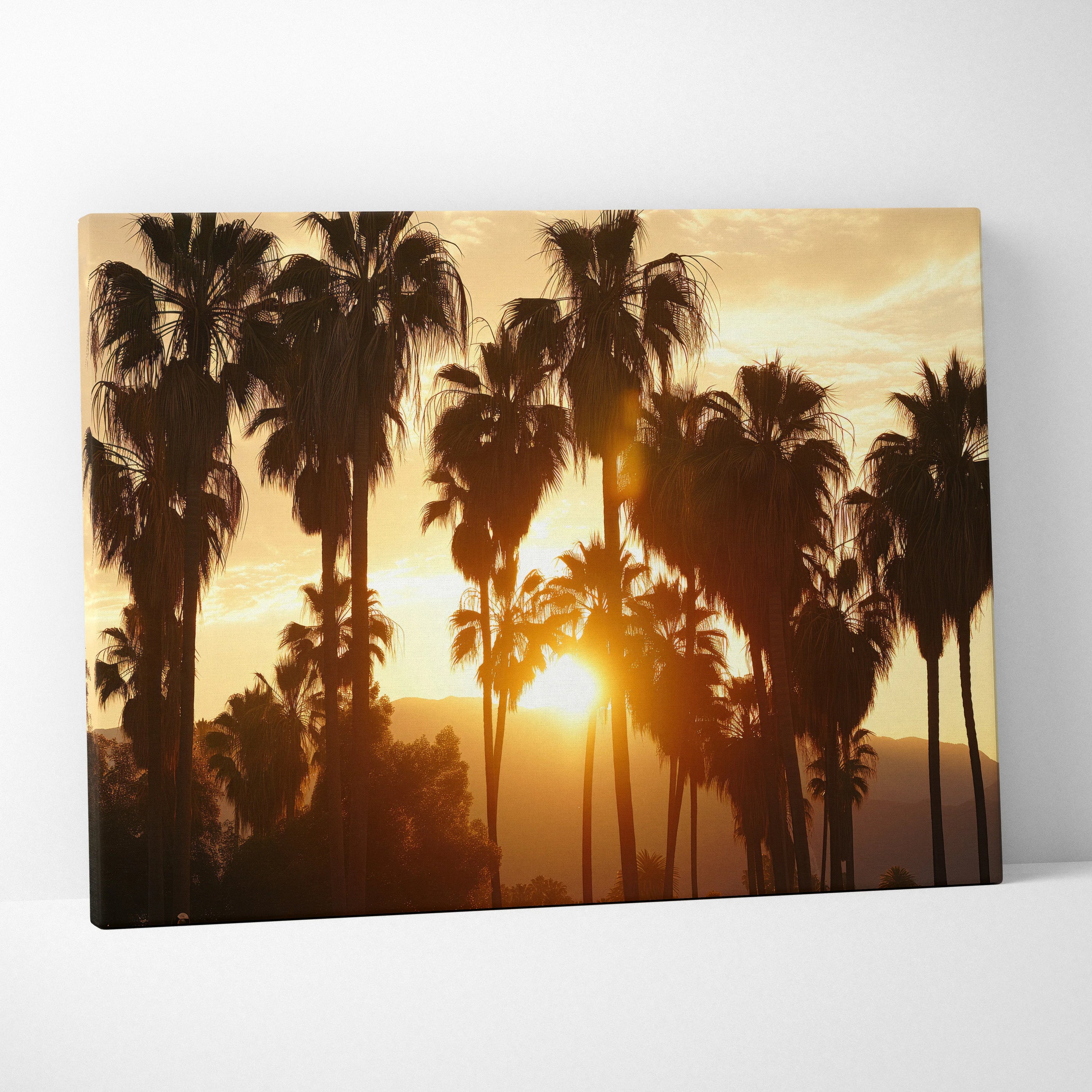 Canvas art featuring silhouette palm trees against a warm tropical sunset with golden orange hues.