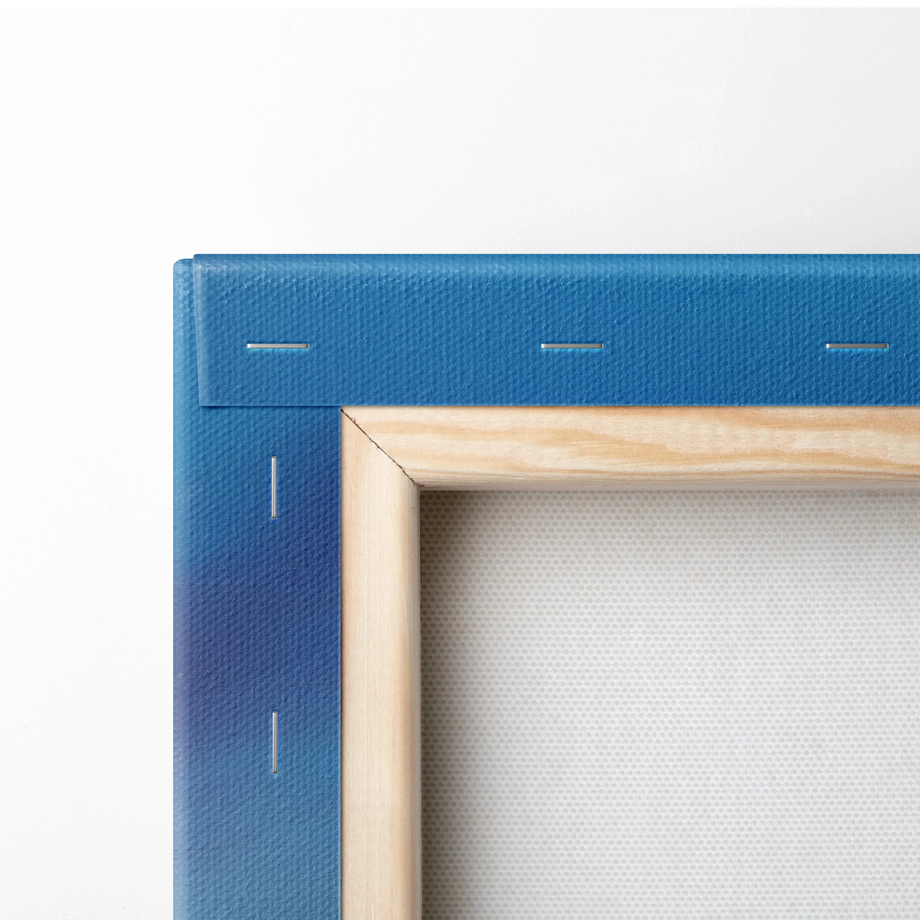 Close-up of canvas art with wooden frame and deep blue gradient on the wrapped fabric edge.