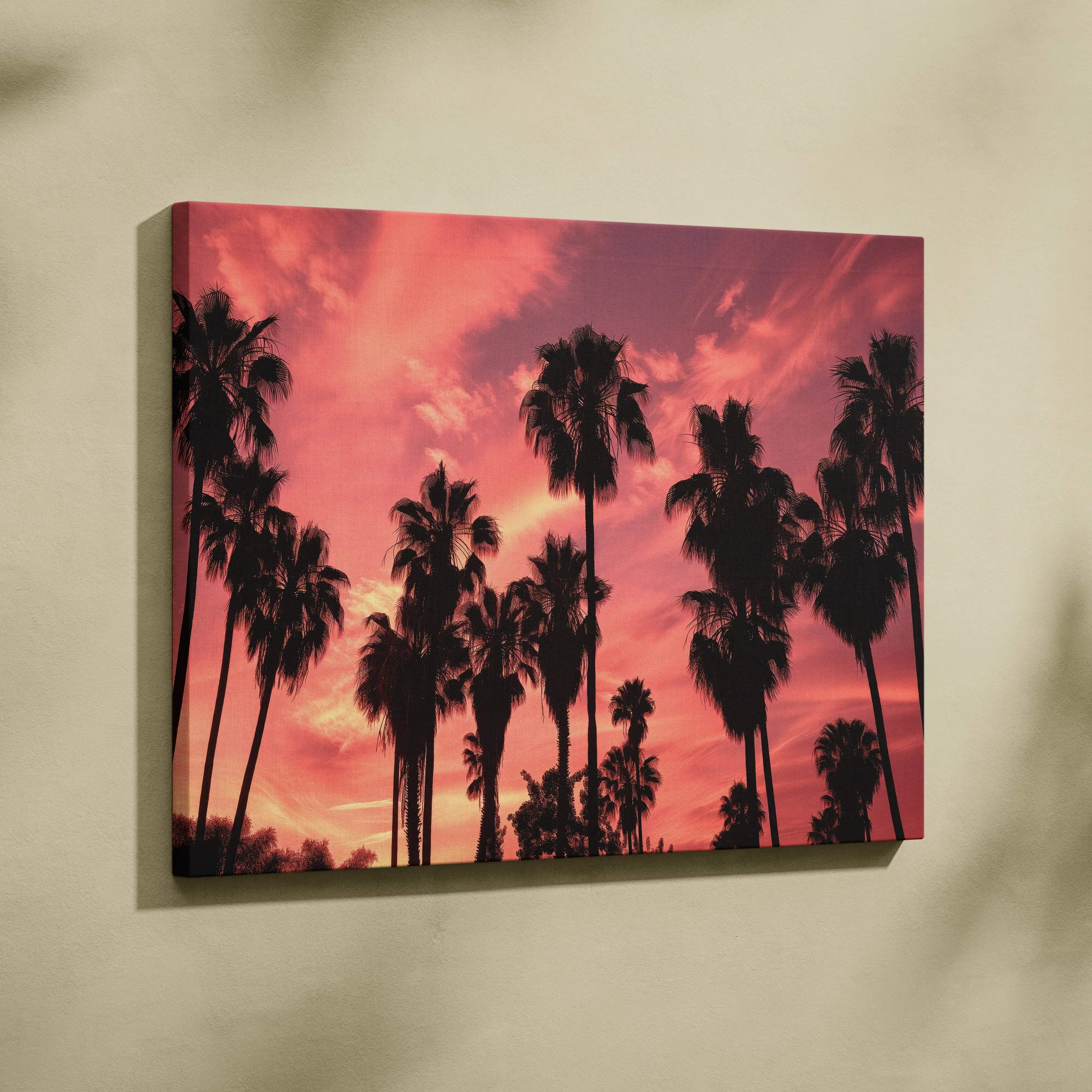 Canvas wall art featuring a vibrant pink and orange sunset with silhouetted palm trees in a tropical coastal mood