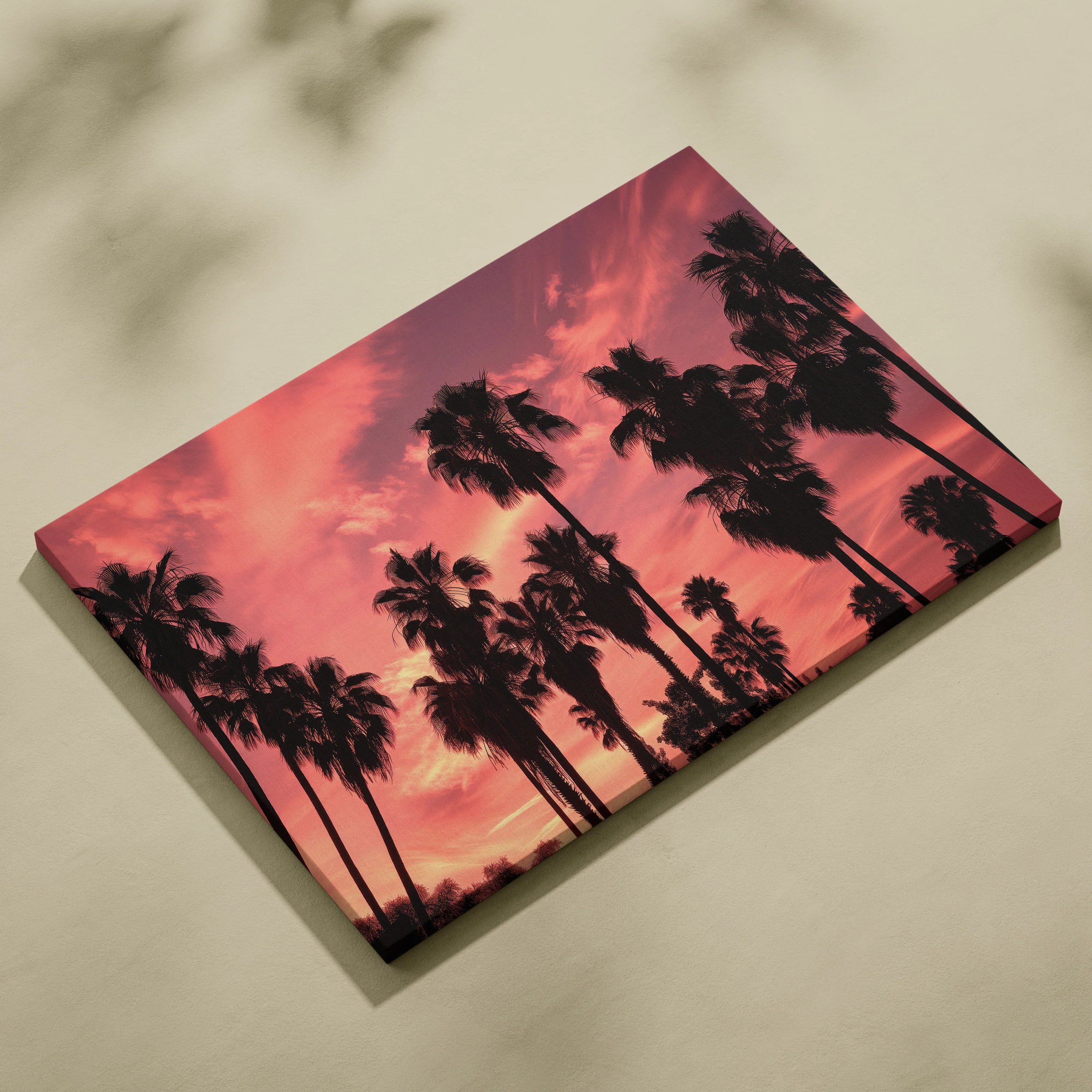 Canvas art depicting black palm tree silhouettes against a vibrant pink and orange sunset sky.