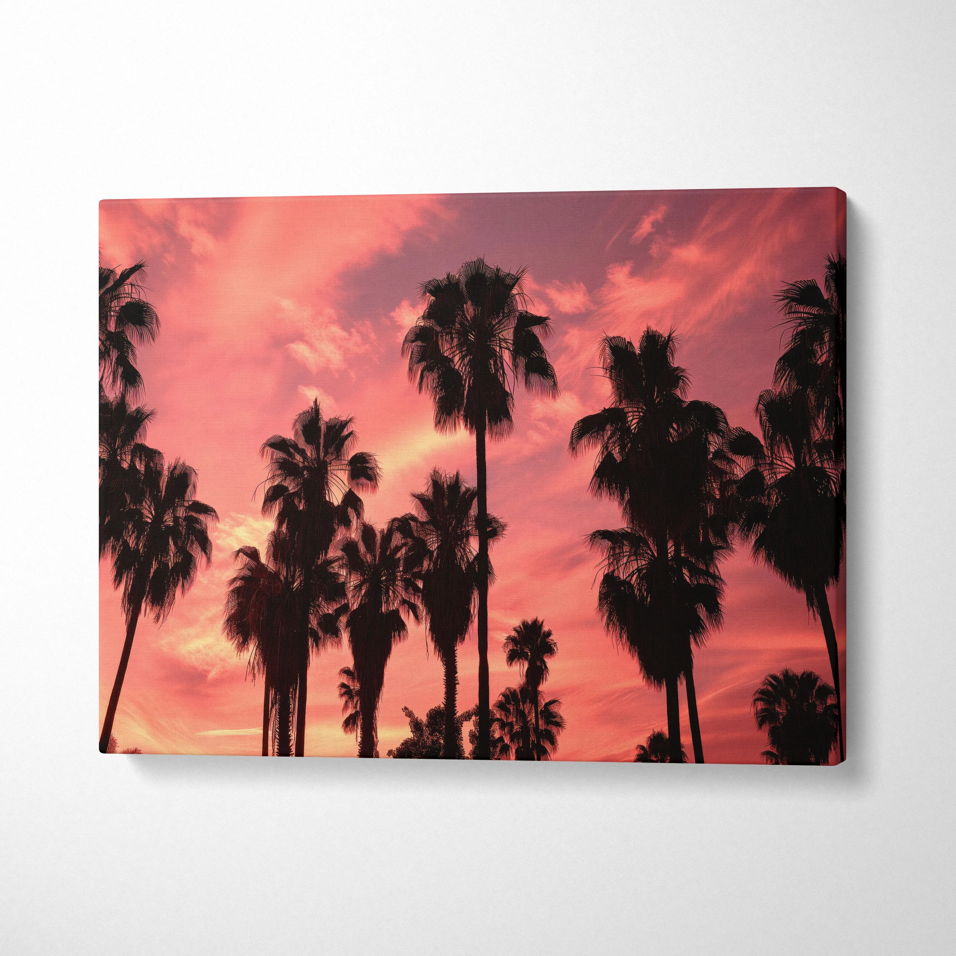 Canvas wall art featuring black palm tree silhouettes against a vibrant pink and orange sunset sky decor.