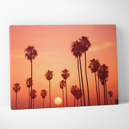 Canvas art print featuring black palm tree silhouettes against a vibrant orange and pink tropical sunset sky.