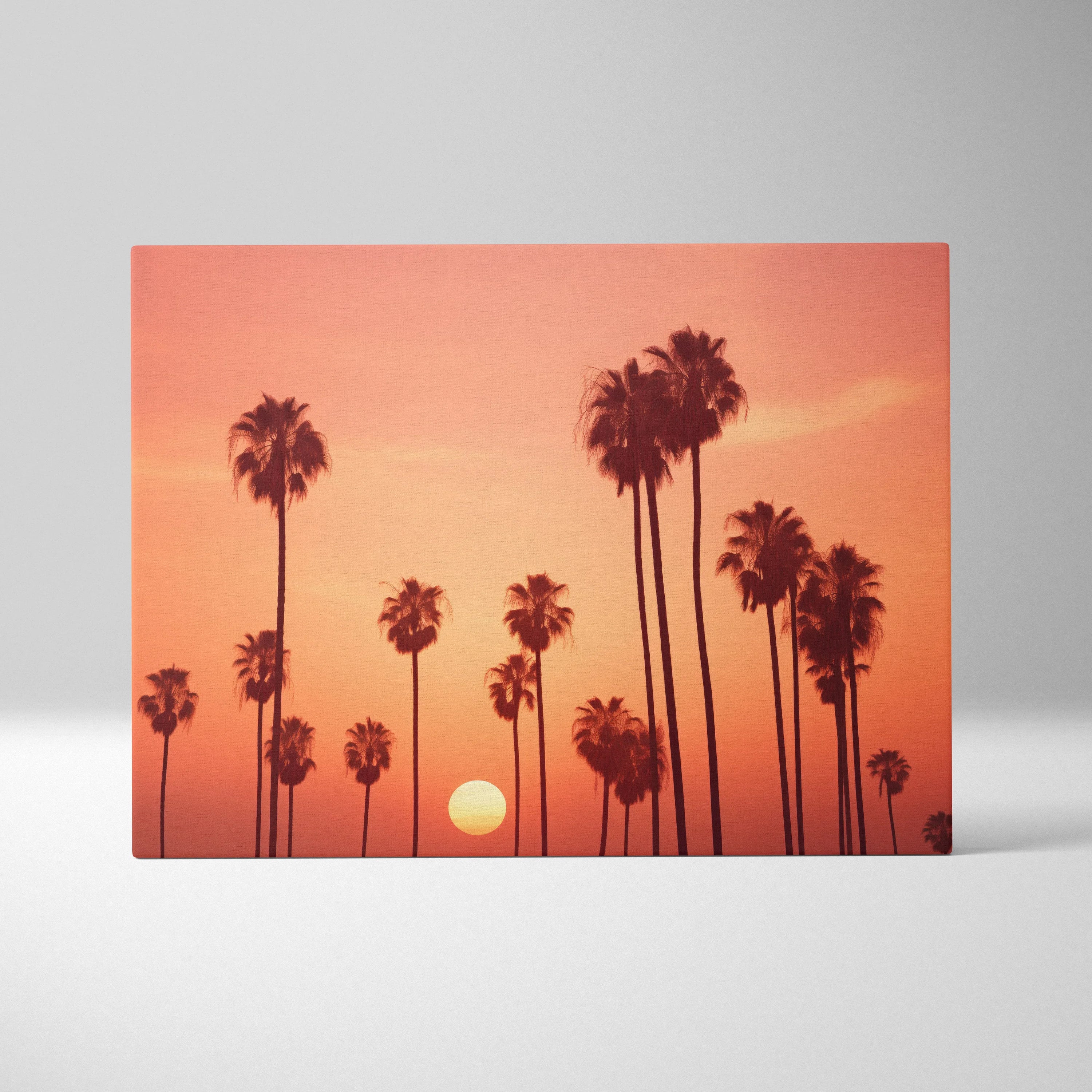 Canvas art print featuring black palm tree silhouettes against a vibrant orange and pink sunset sky.