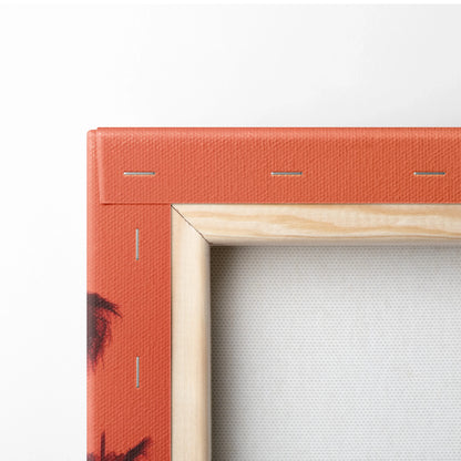 Corner of stretched canvas print with tropical orange and red sunset design and wooden frame back visible.