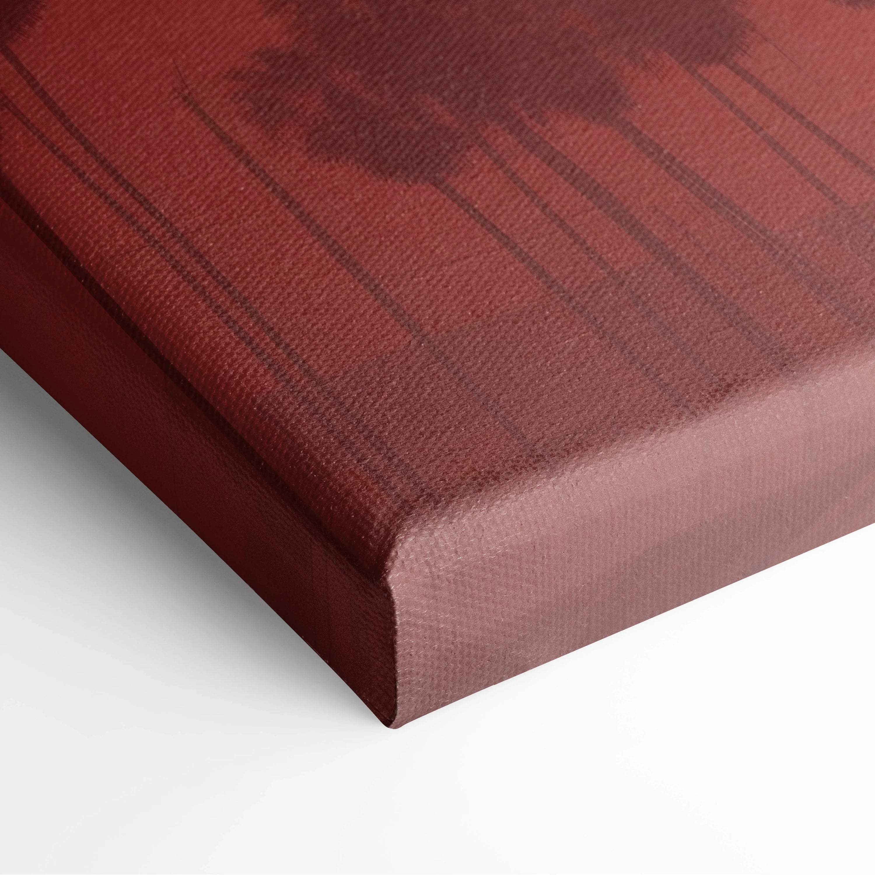 Close-up of canvas print corner featuring dark tropical palm tree silhouettes against a deep red sunset background.