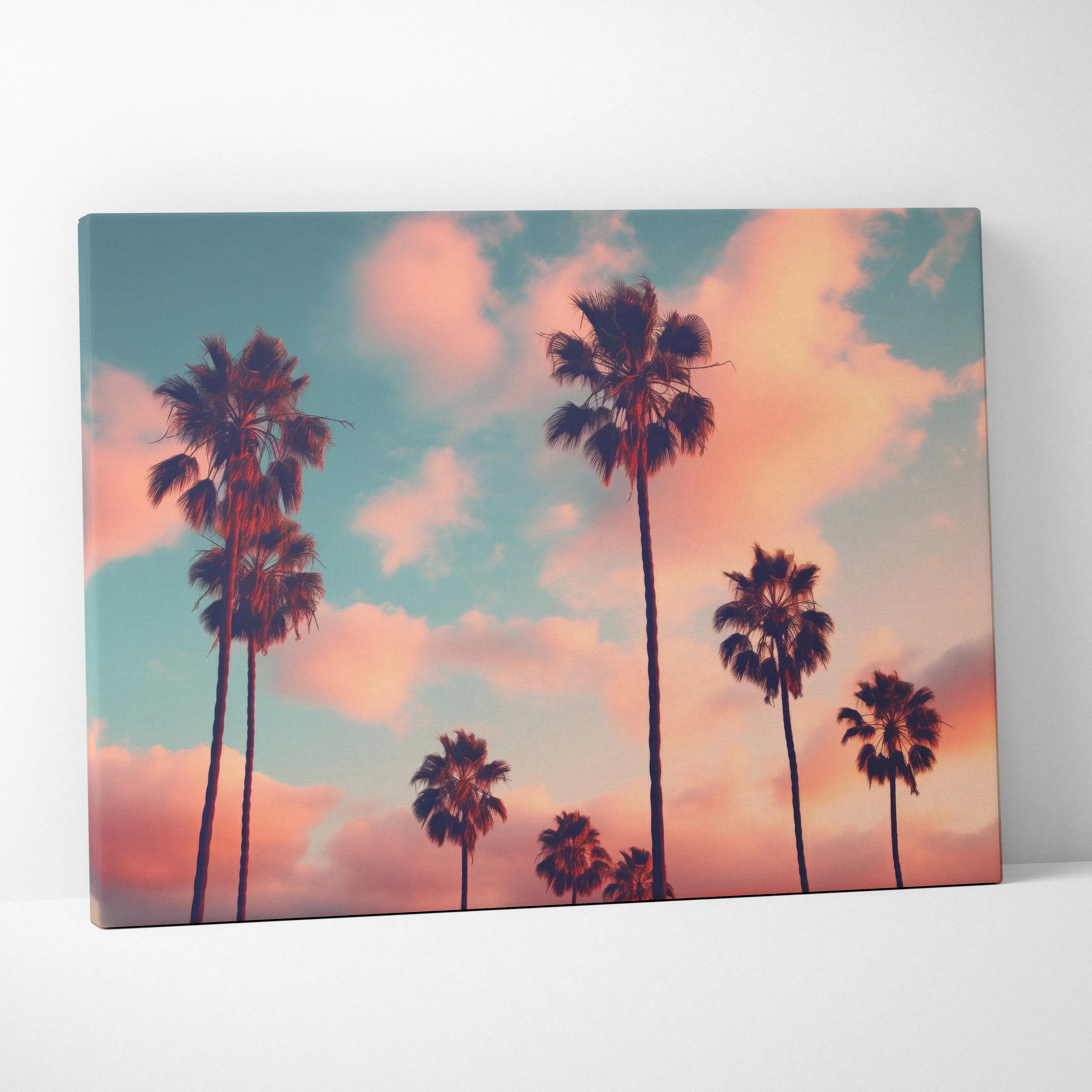 Canvas wall art featuring black palm tree silhouettes against a colorful pink and blue tropical sunset sky.