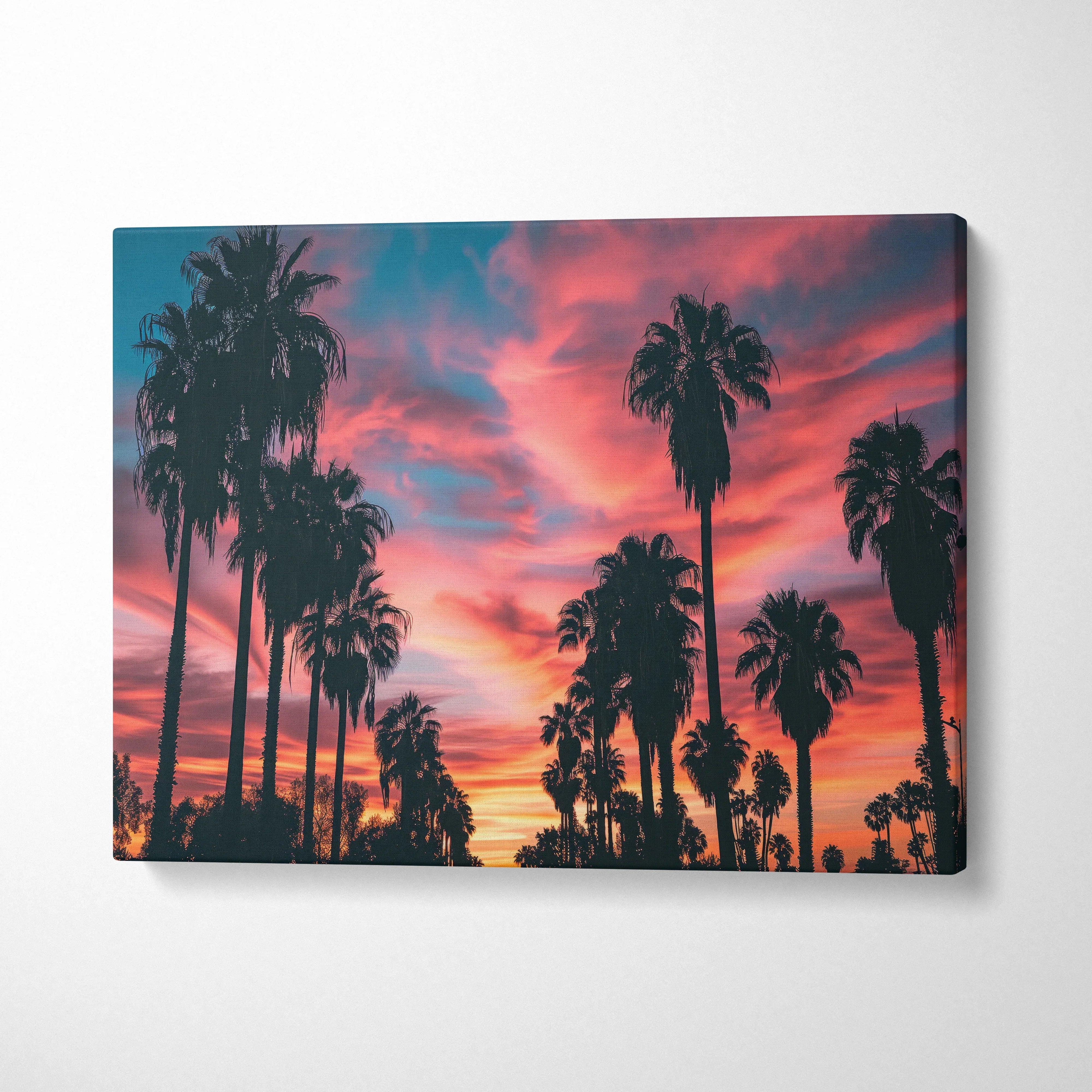 Tropical sunset canvas wall art with silhouette palm trees against orange and pink sky decor.