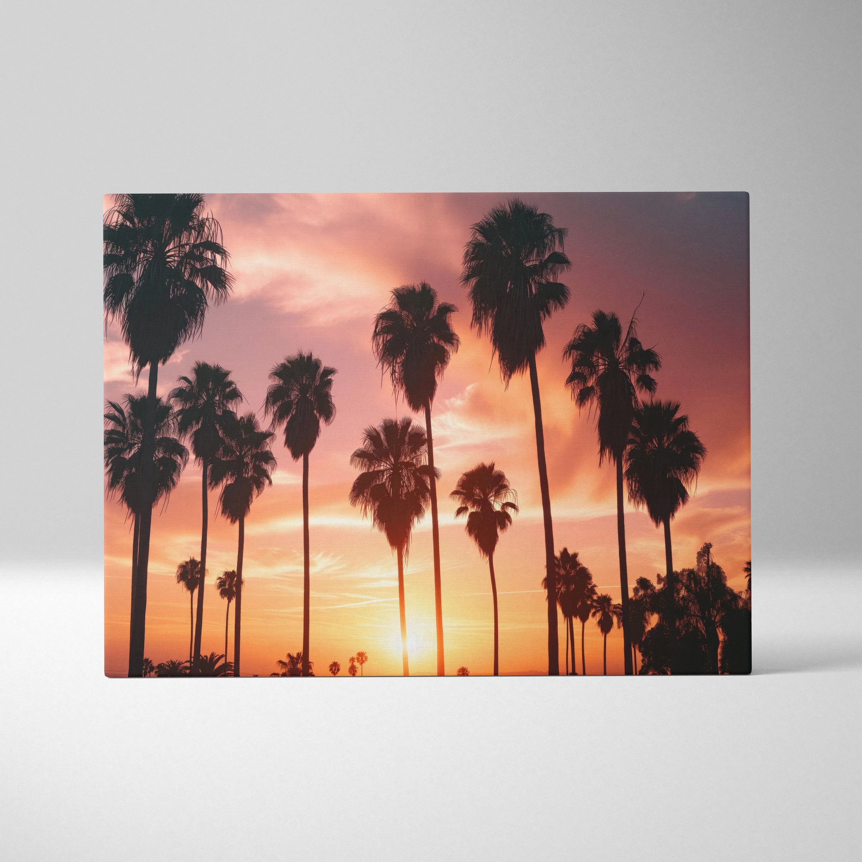 Canvas art featuring silhouetted palm trees against a vibrant tropical sunset sky with orange and purple hues.