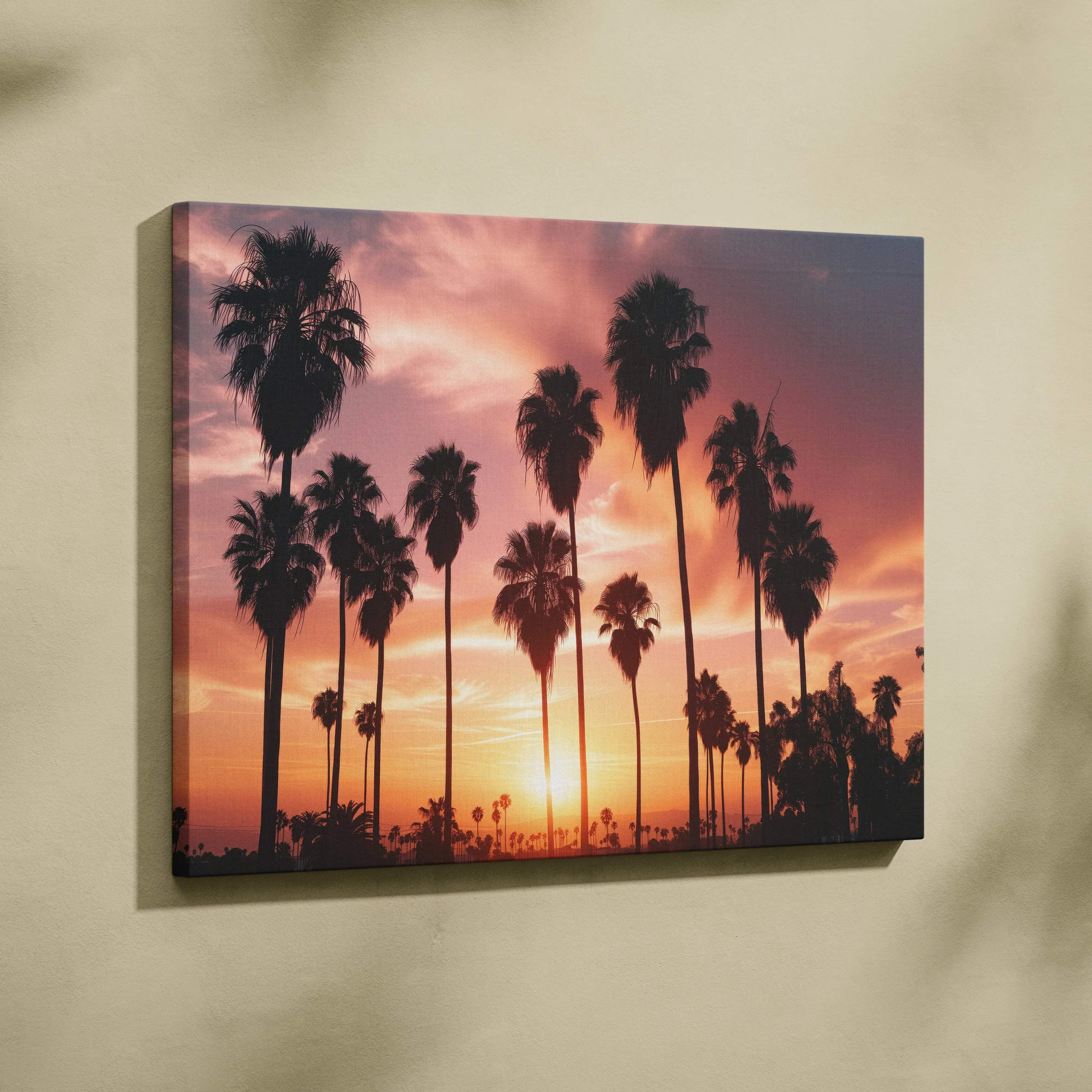 A vibrant canvas wall art featuring silhouetted palm trees against a warm orange pink and purple sunset sky