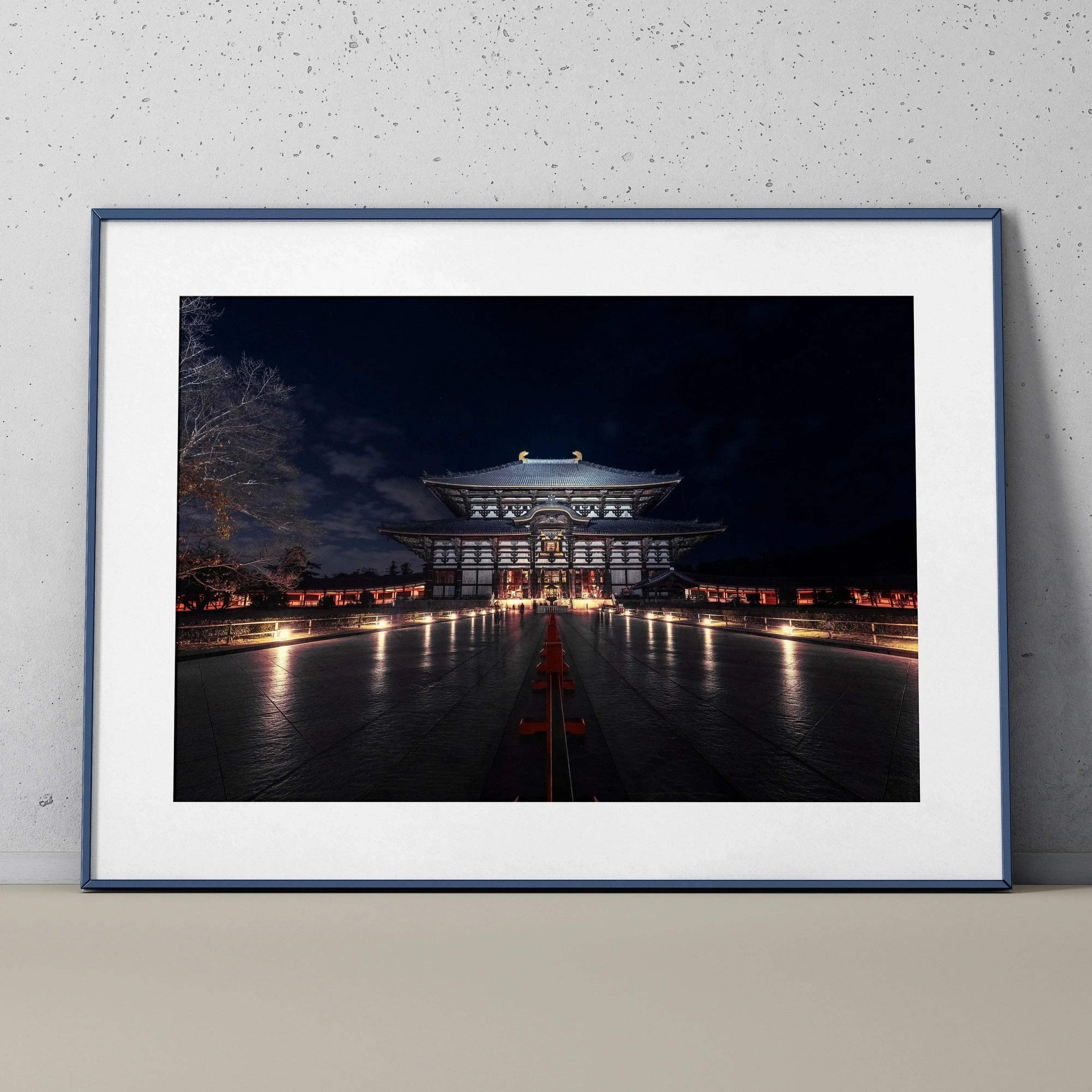 Night city building illuminated with warm lights, modern wall art poster with dark sky background.