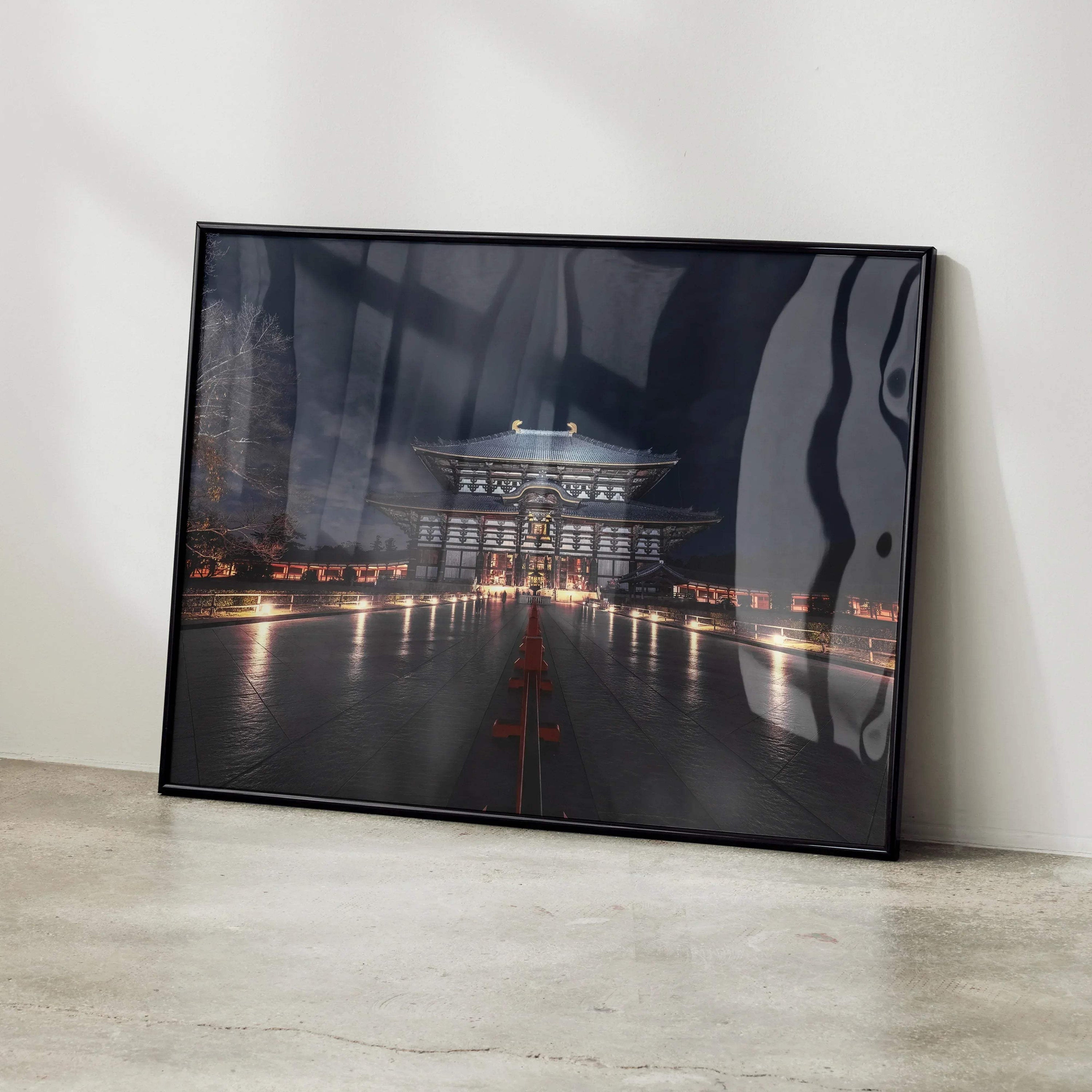 Dark night city building art poster with illuminated walkway, modern wall art in black frame.