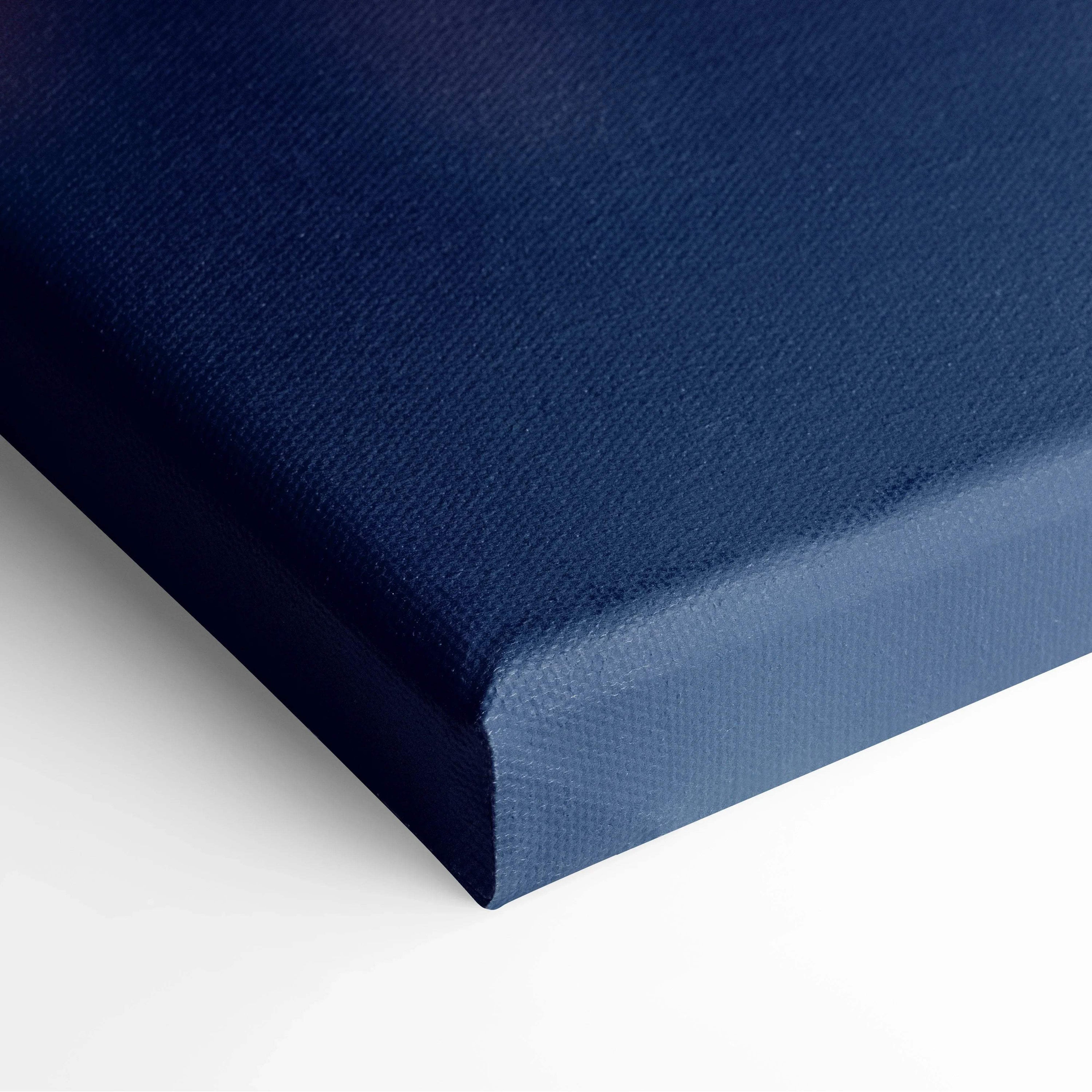 Close-up of deep blue canvas corner edge highlighting textured fabric and thick fold for wall art.