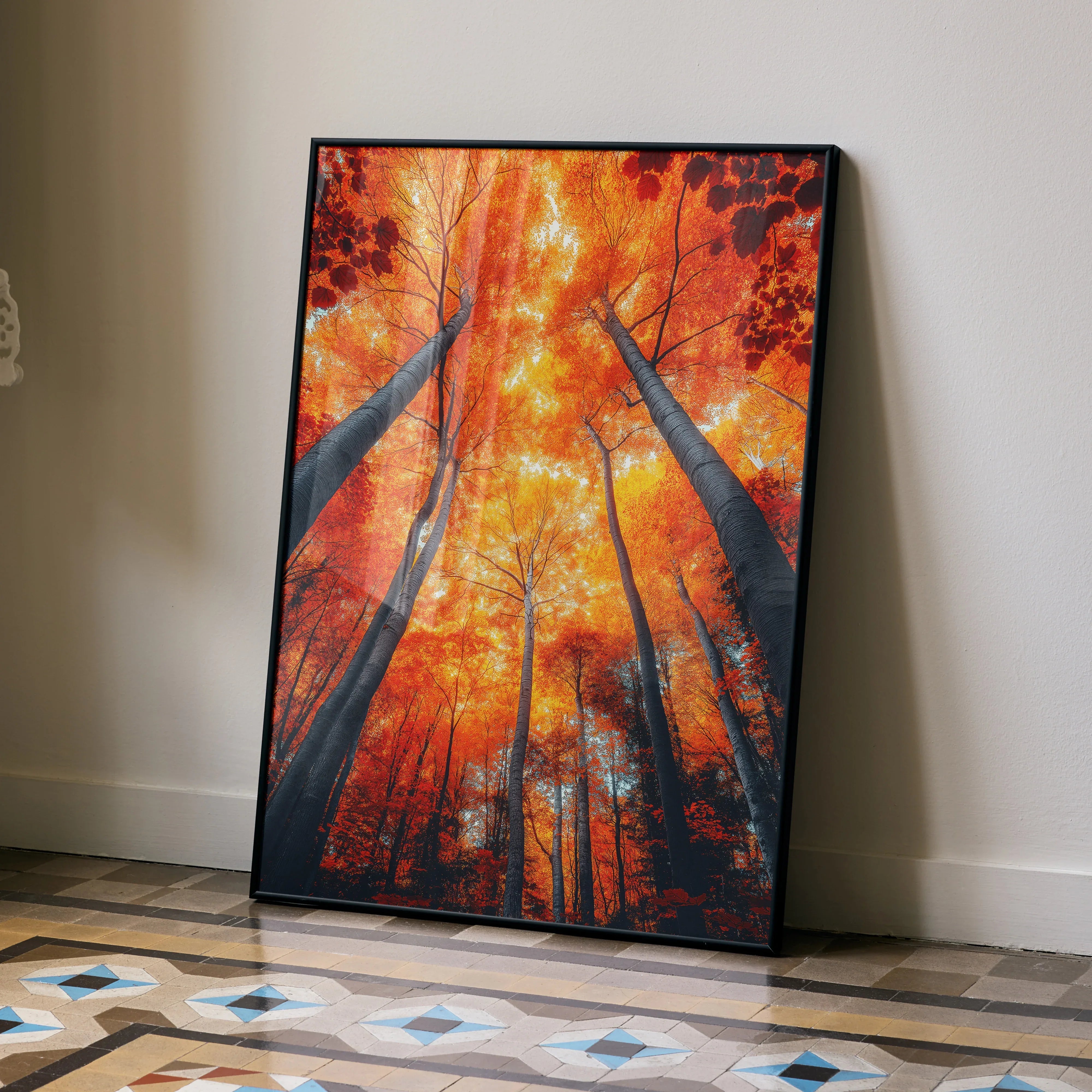 Vertical poster wall art featuring vibrant autumn trees with fiery orange leaves and dark tree trunks reaching skyward.