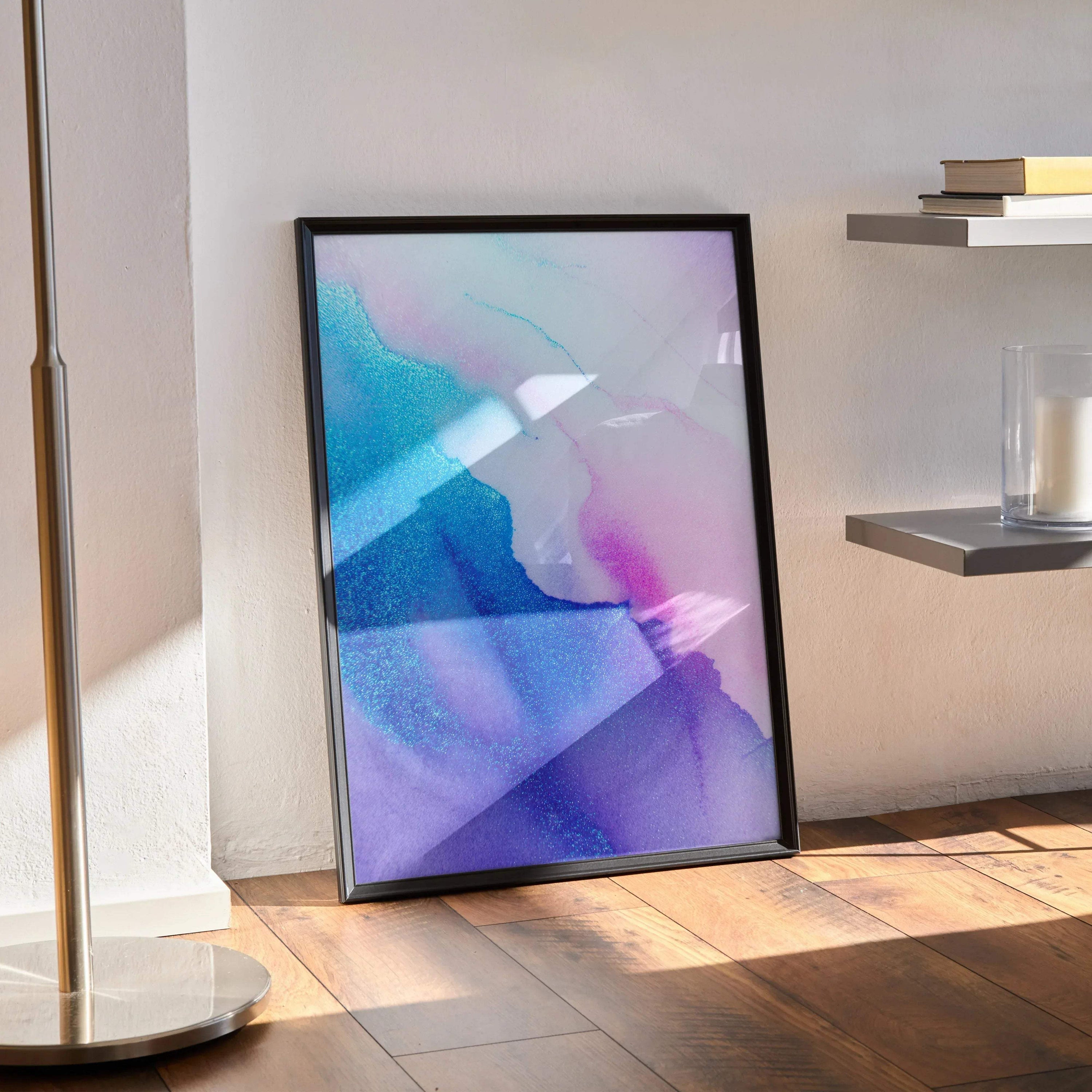 Abstract modern art poster with bold blue, purple, and pink geometric patterns in black frame leaning on wall, wall art.