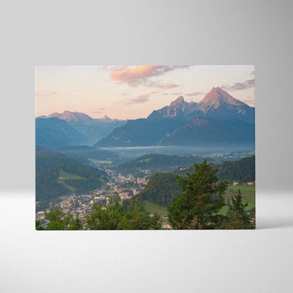 Mountain sunset canvas wall art print featuring a village by forested hills under colorful sky.
