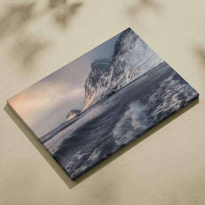 Canvas wall art featuring dramatic mountains and ocean waves under a soft sunset sky.