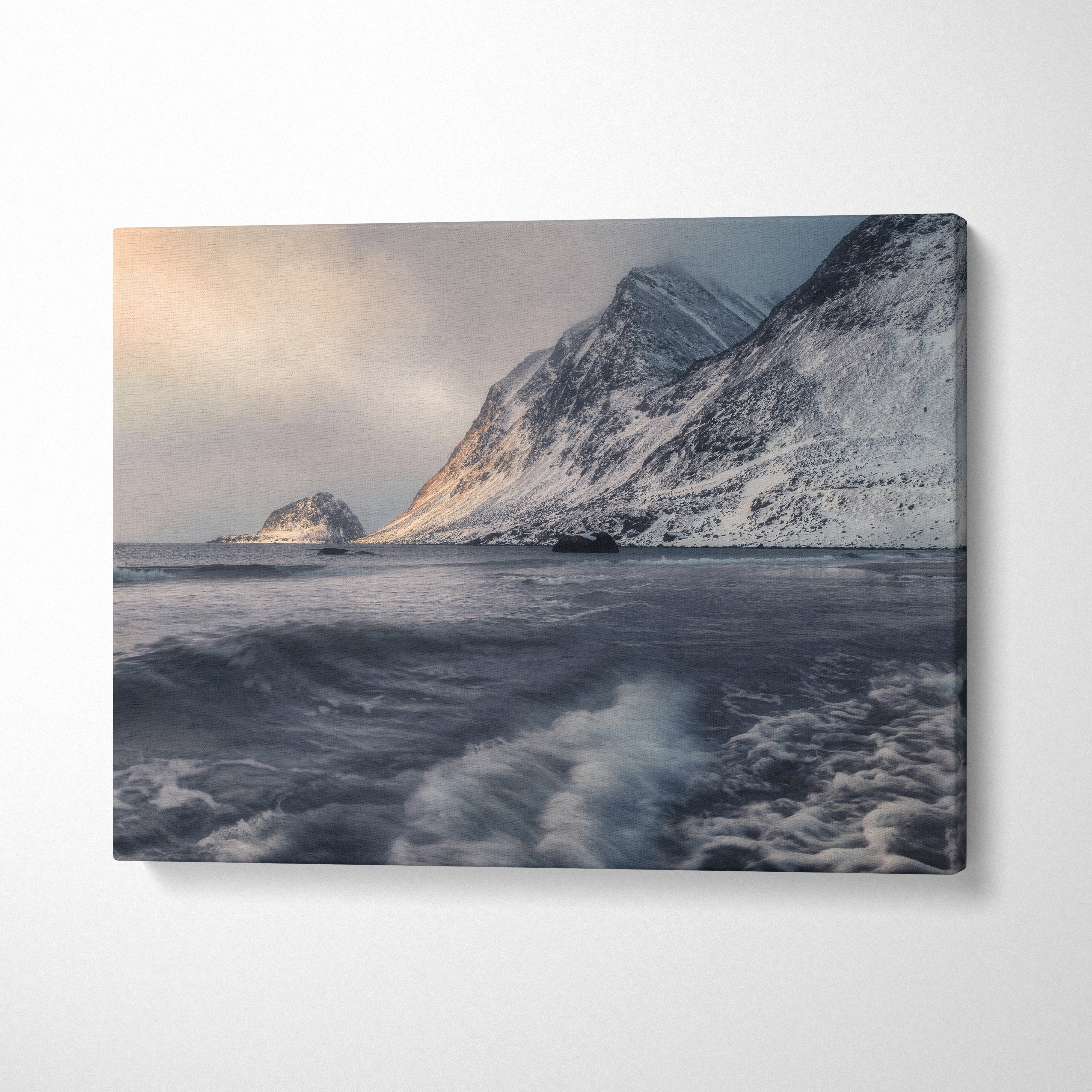 Canvas wall art depicting snowy mountains under a cloudy sky with turbulent water in front.