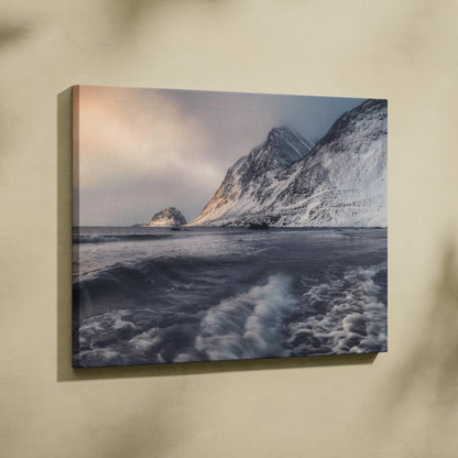 Canvas wall art featuring snowy mountains against a moody sky over turbulent ocean waves.