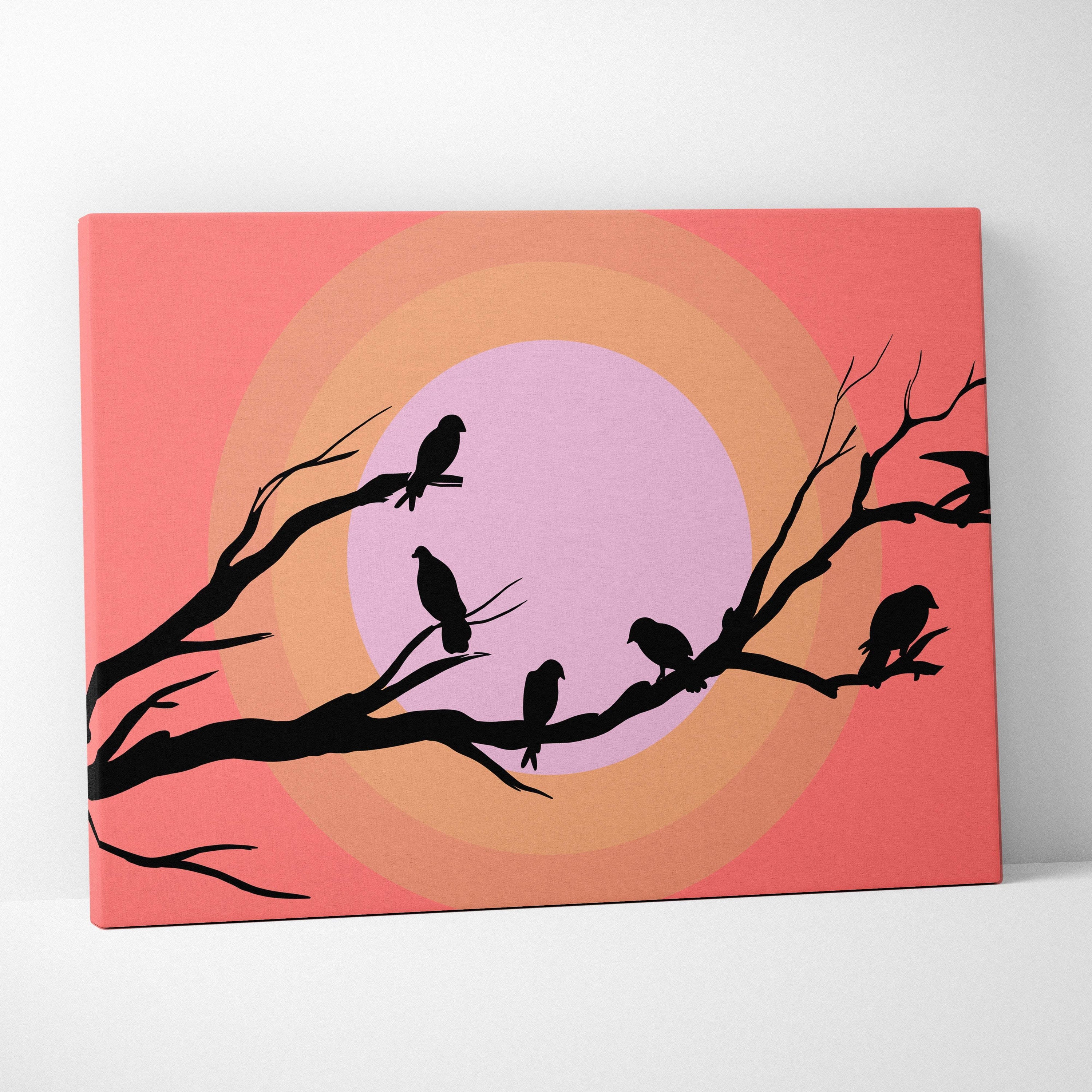 A rectangular canvas print of black bird silhouettes on branches with a pink to orange gradient background coral tones