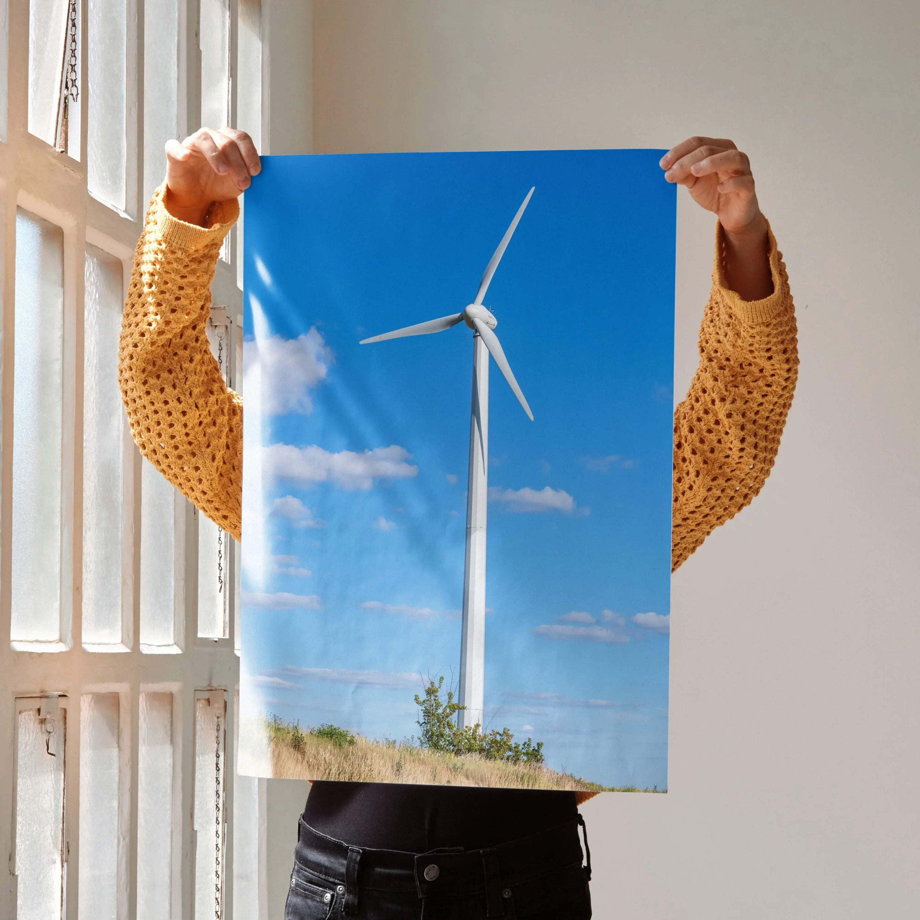 Vertical wall art poster of a white windmill against a bright blue sky with scattered clouds.