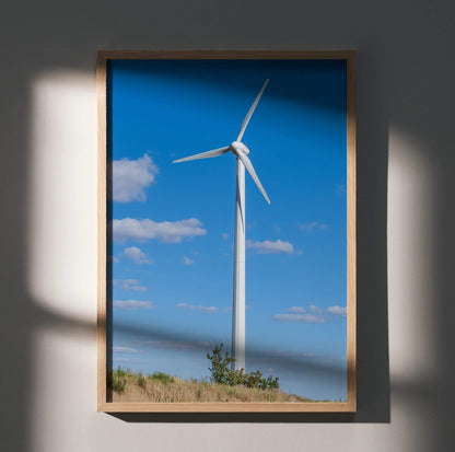 Vertical wall art poster featuring a single white windmill against a vibrant blue sky with scattered clouds.