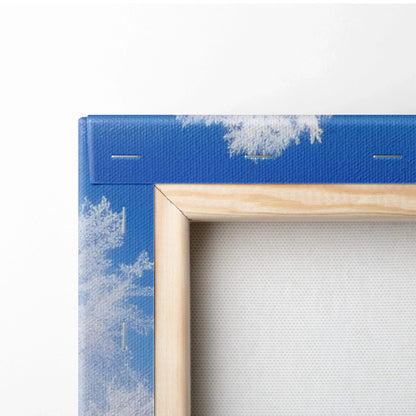 Blue canvas with white snowflake patterns wrapped around a wooden frame corner for wall art decor.