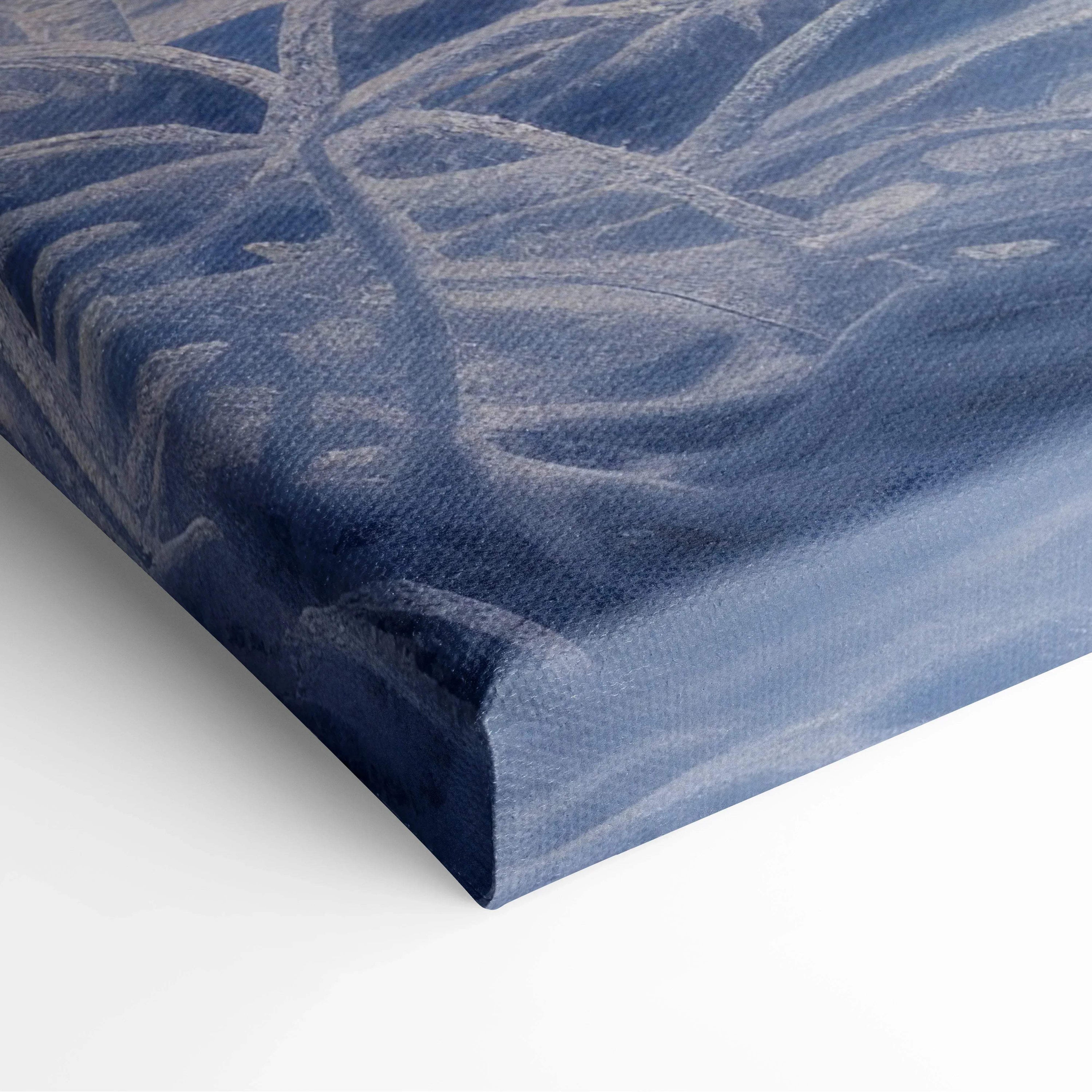 Close-up of canvas texture with blue and gray brushstrokes on stretched wooden frame corner.
