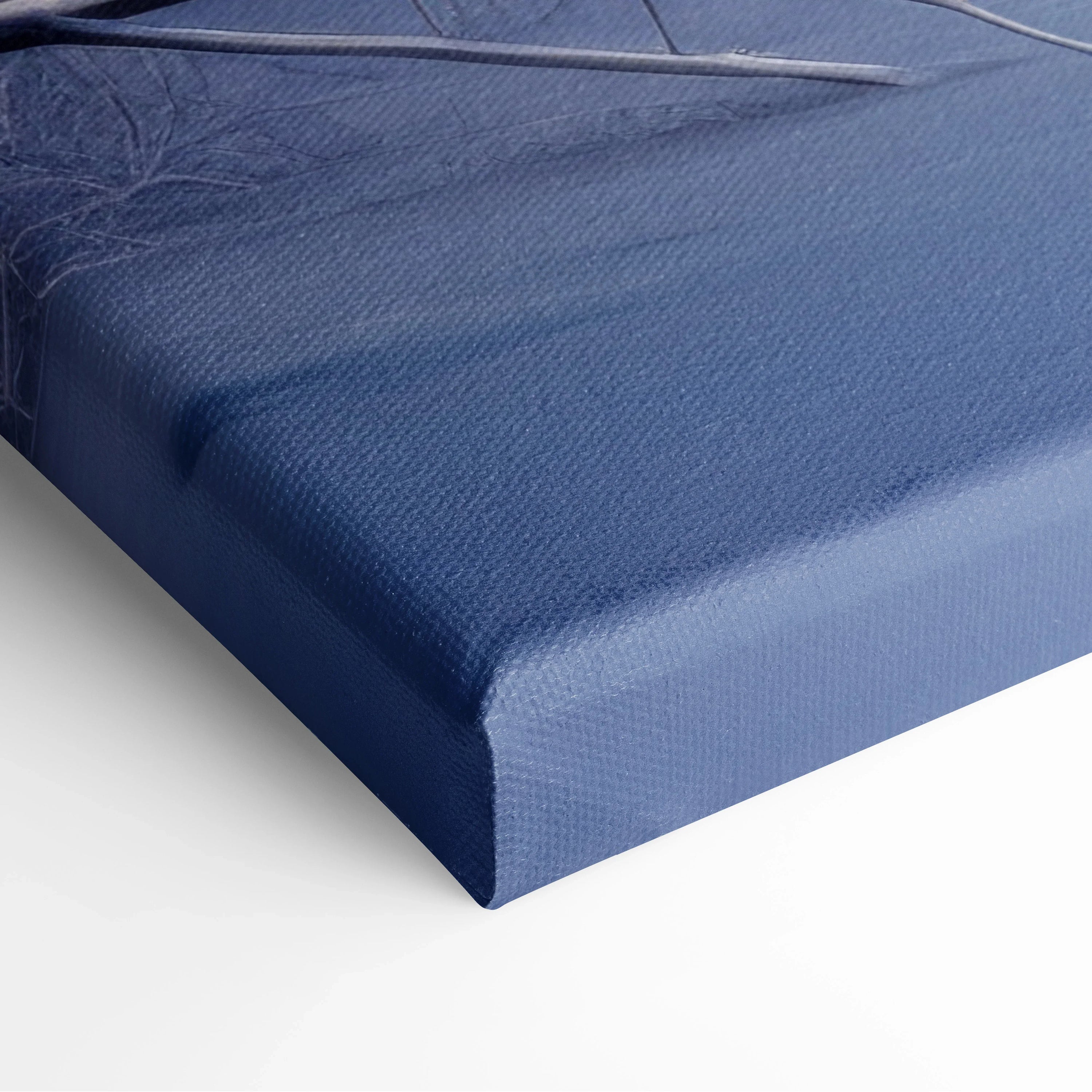 Close-up of canvas edge with textured fabric in deep blue, highlighting quality and sturdy frame for wall art decor.