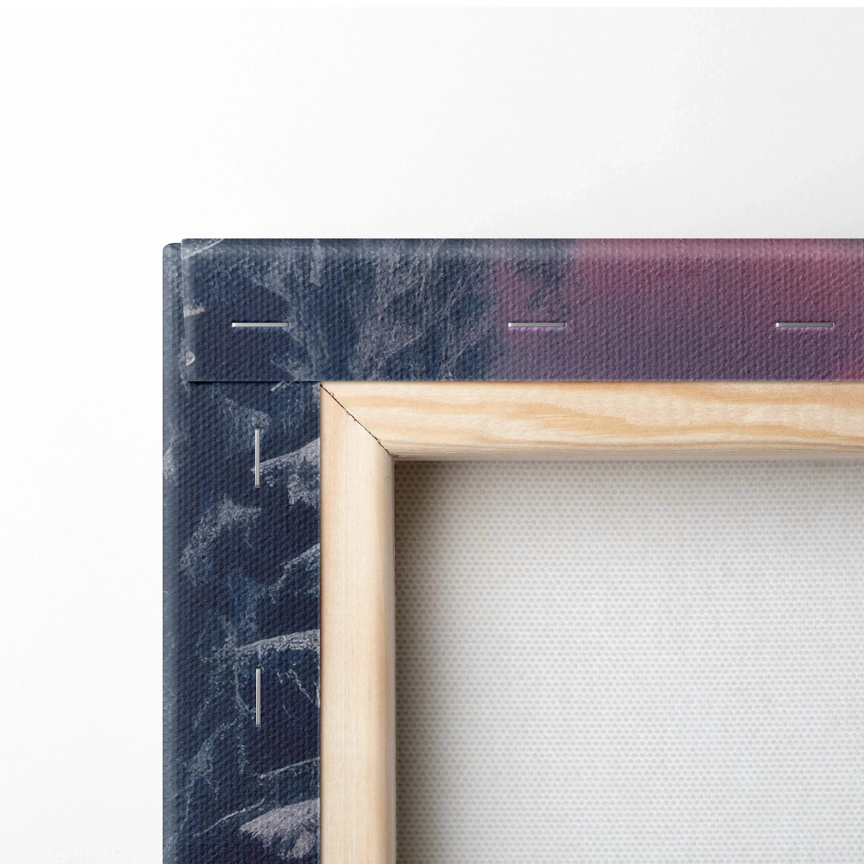 Close-up of wooden stretcher frame with snowy sunset canvas print wrapped on textured canvas material.