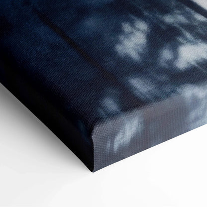 Close-up of a dark blue digital canvas wall art corner with snowy winter scenery and textured fabric surface.