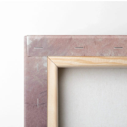 Close-up of wooden frame and stapled edge of a wrapped canvas print with light pink and beige tones.