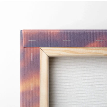 Corner view of wood-framed canvas wall art with snowy sunset colors in purple and orange tones.