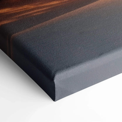 Close-up of canvas wall art with textured surface and dark, warm sunset colors along the edge.