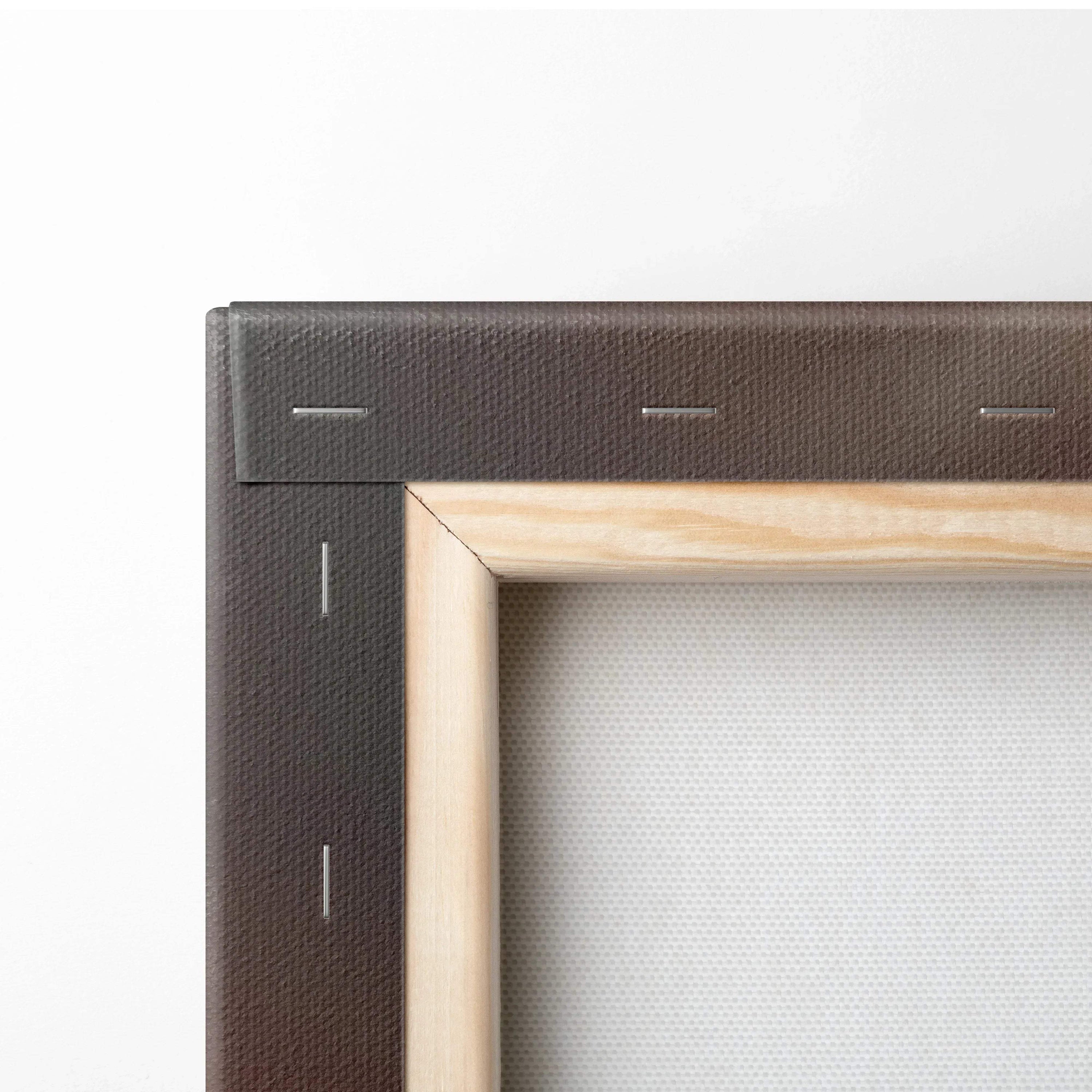 Close-up of a wooden frame corner with a stapled black canvas backing for wall art display.