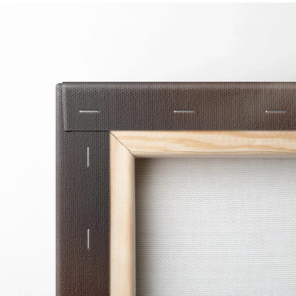 Close-up of a wooden frame corner with a stapled black canvas backing for wall art display.