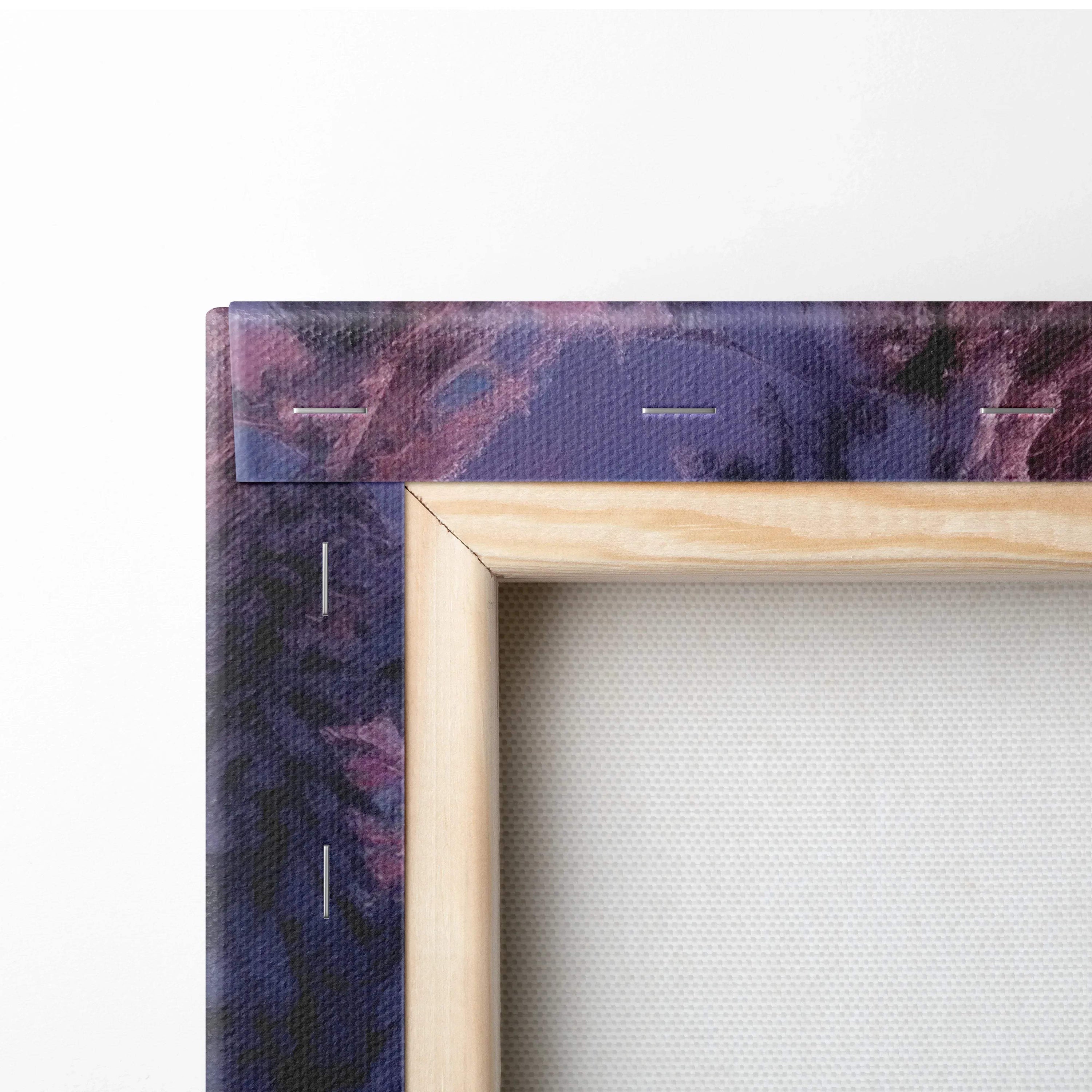 Close-up of canvas wall art corner showing wooden frame and snowy sunset digital print with purple and dark blue tones.