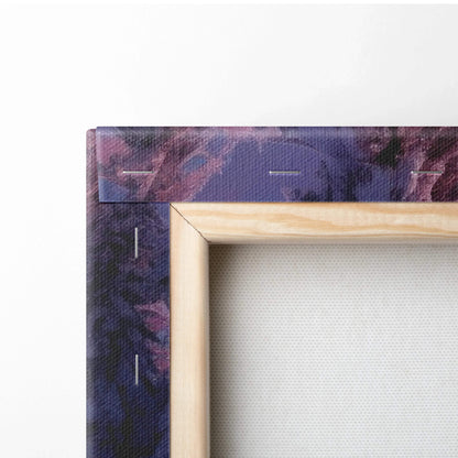 Close-up of canvas wall art corner showing wooden frame and snowy sunset digital print with purple and dark blue tones.