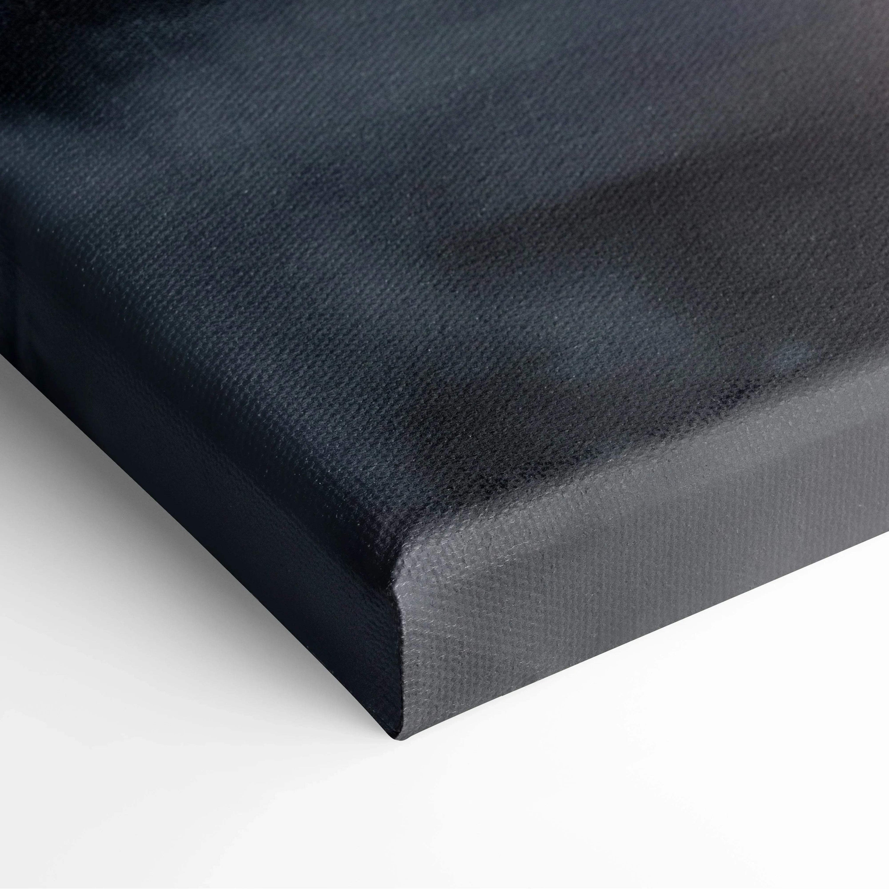 Close-up of black-wrapped edge canvas art with smooth textured surface and sharp corner.