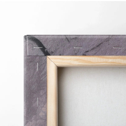 Close-up of wooden stretcher frame corner with gray printed canvas stretched tightly and stapled on back.