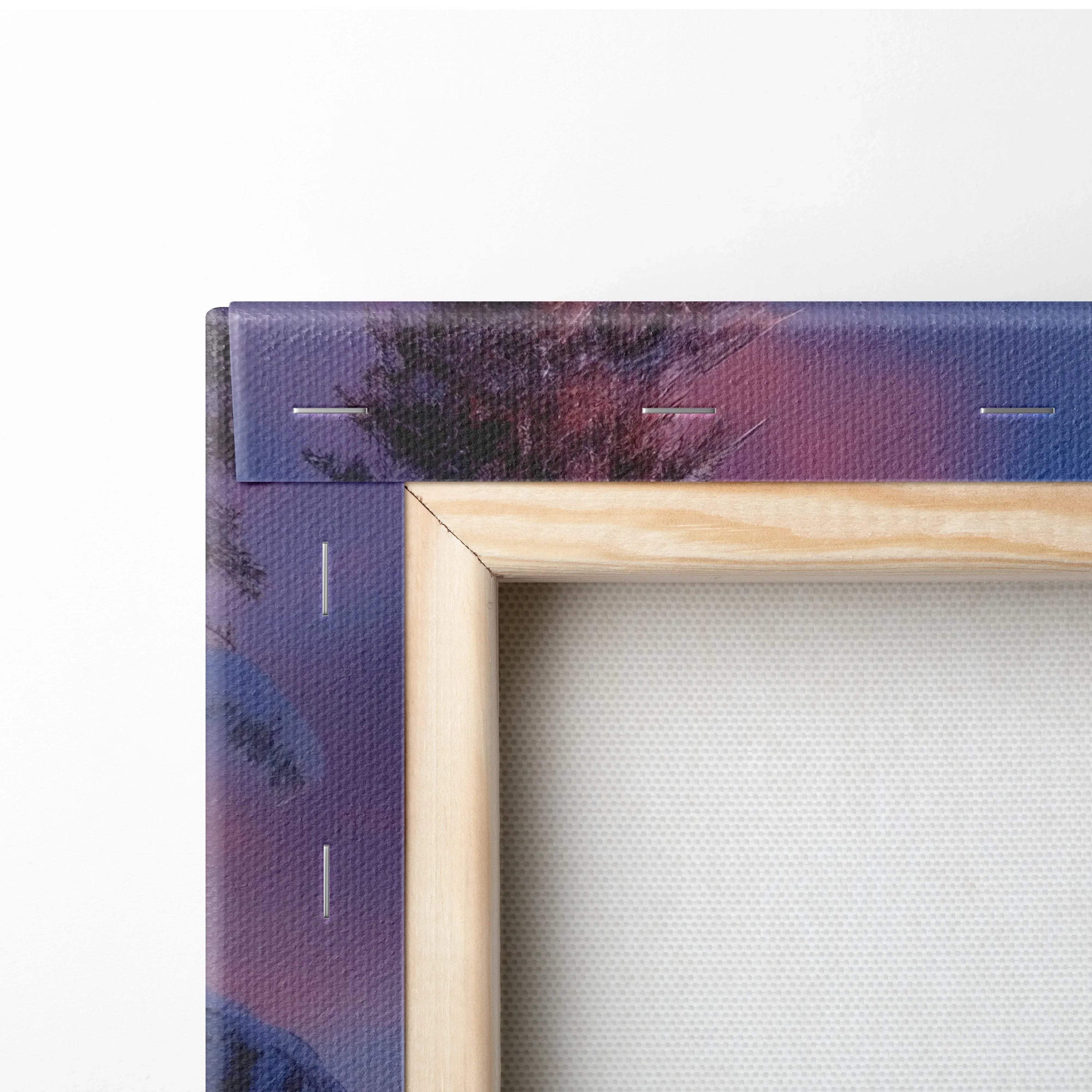 Close-up of wooden-framed canvas wall art with purple and pink snowy sunset print on wrapped edges.