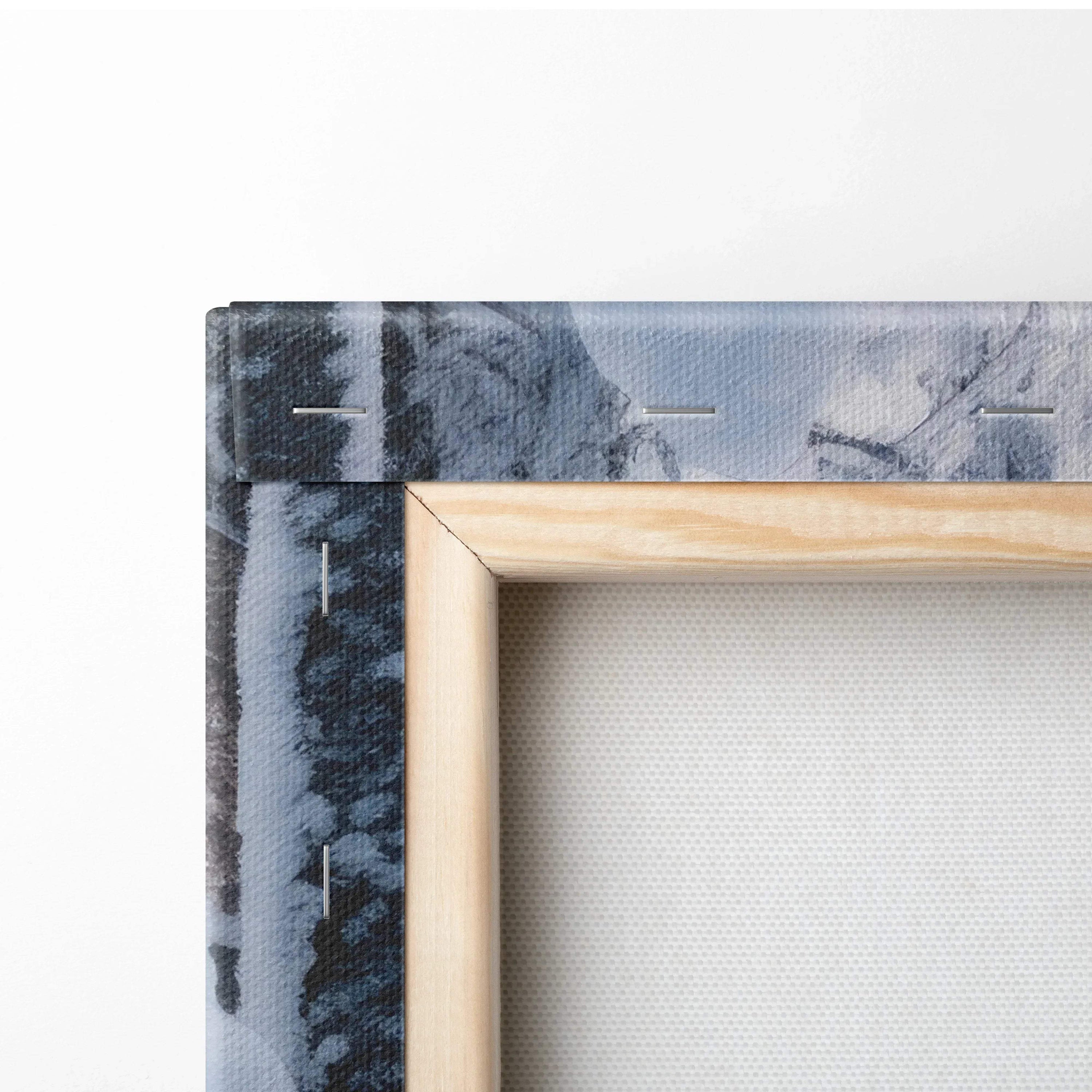 Close-up of wooden-framed canvas print showing snowy forest with blue-gray tones and textured surface.