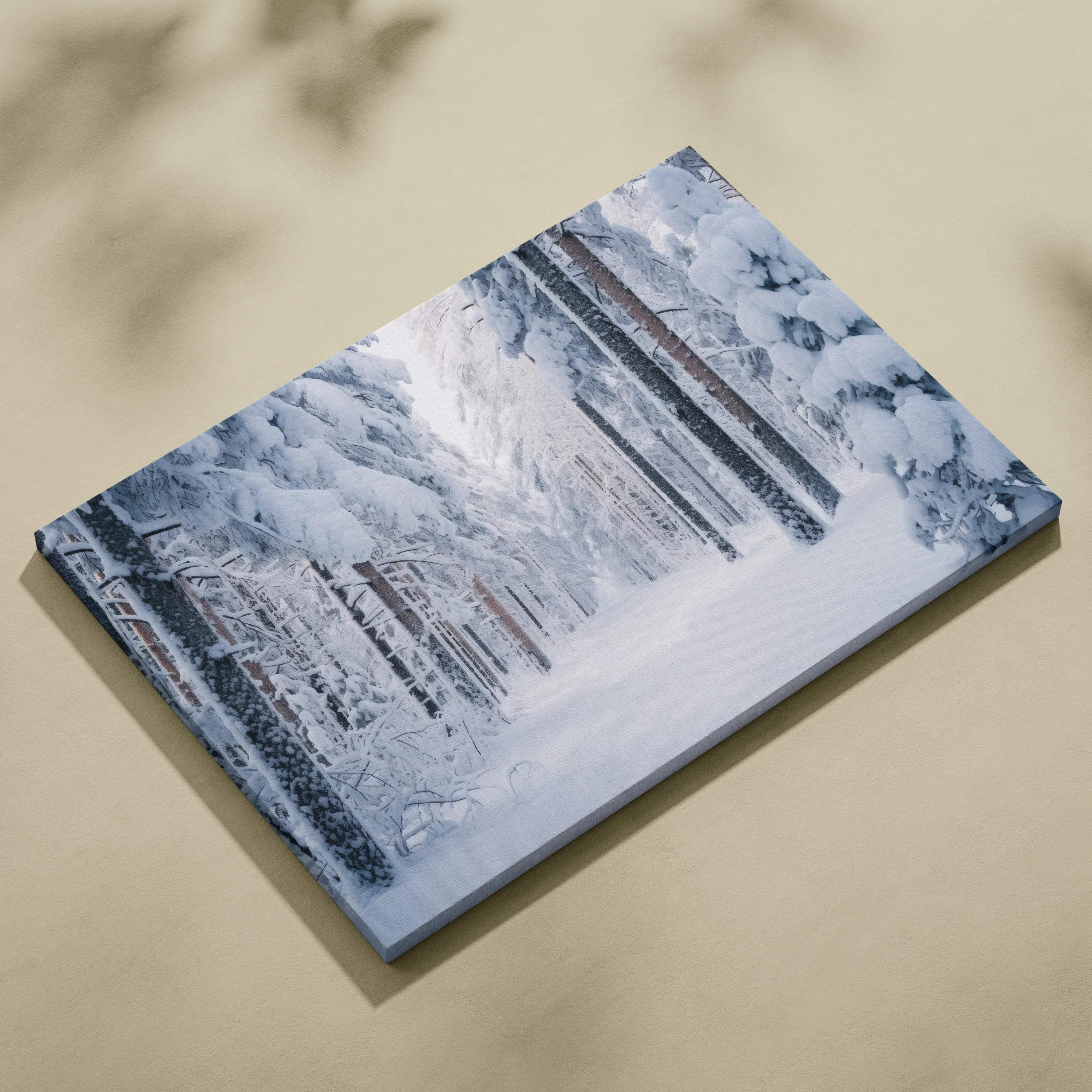Canvas wall art featuring a serene snowy forest landscape with tall snow-covered trees and soft blue-gray tones.
